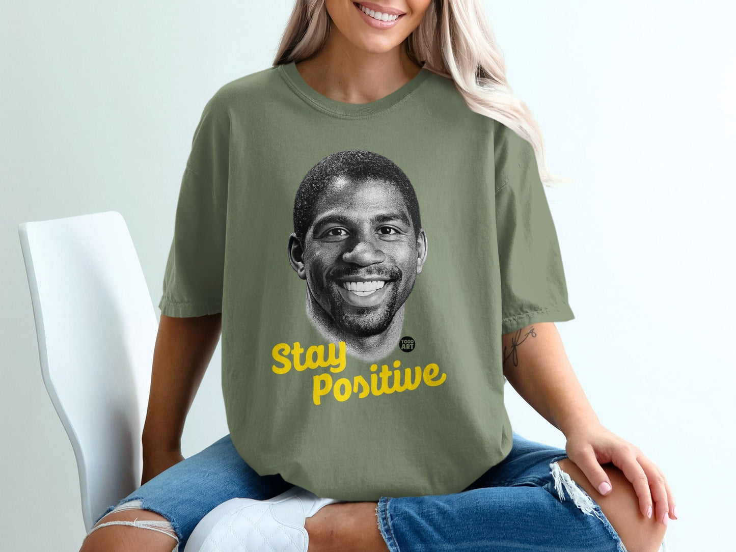 Green t-shirt with Magic Johnson's portrait and "Stay Positive" text.