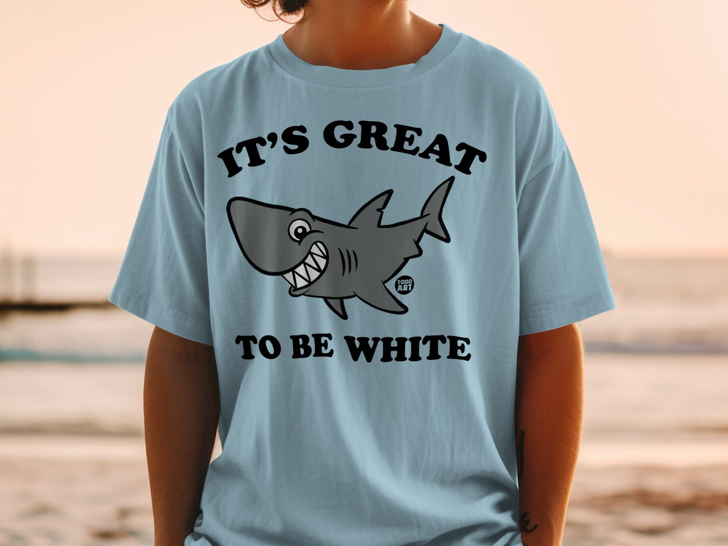 Light blue t-shirt with smiling cartoon shark and text "IT'S GREAT TO BE WHITE".