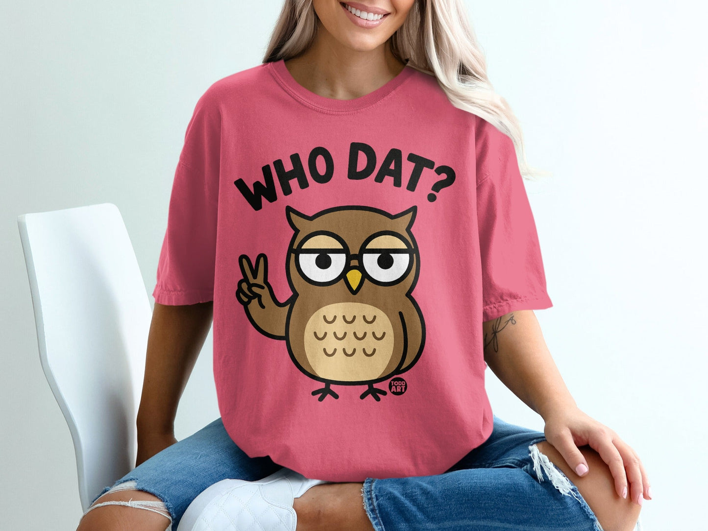 Pink t-shirt with cartoon owl giving peace sign and text "WHO DAT?".