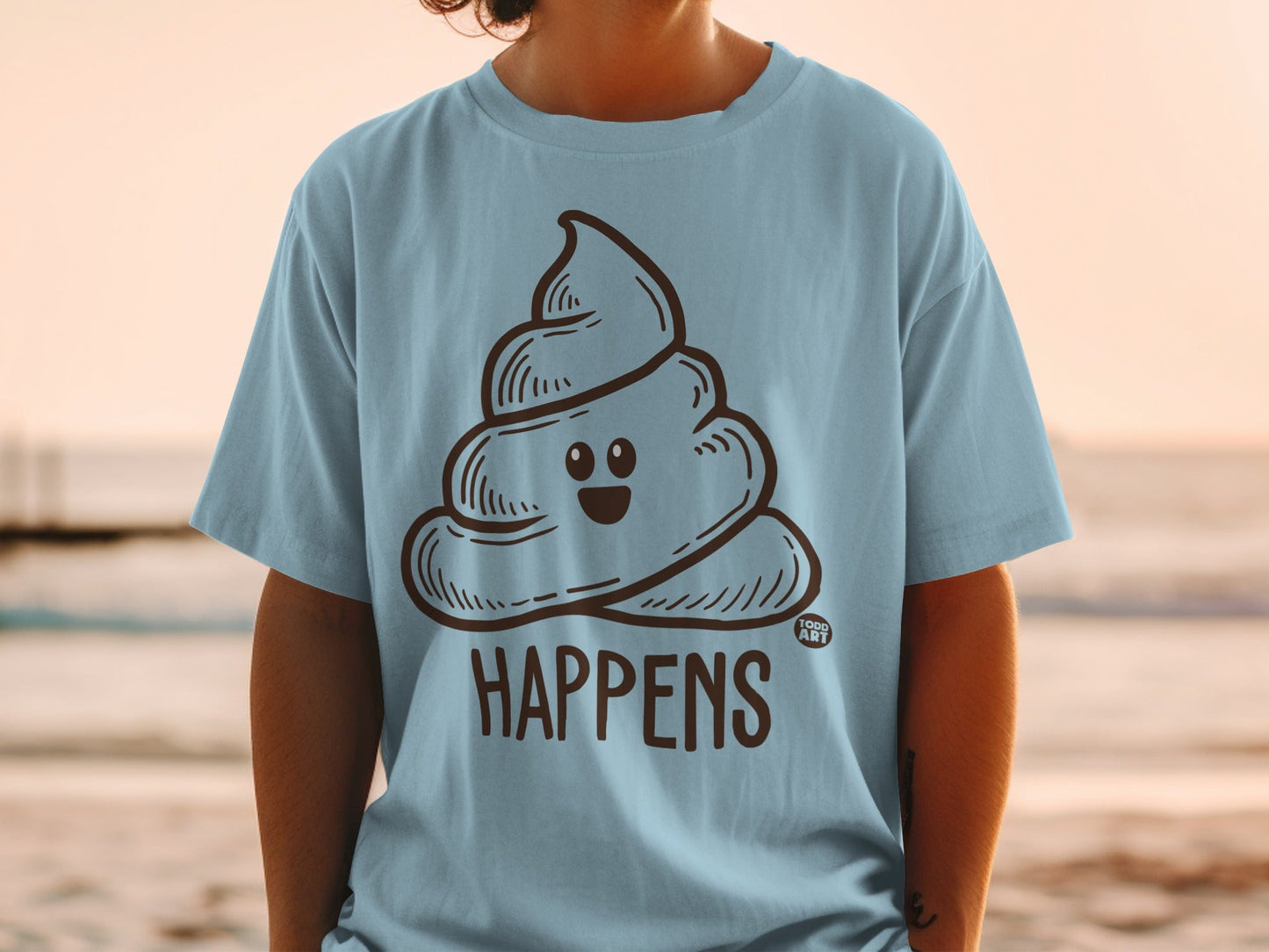Light blue t-shirt with a cartoon smiling poop emoji and "HAPPENS" text.