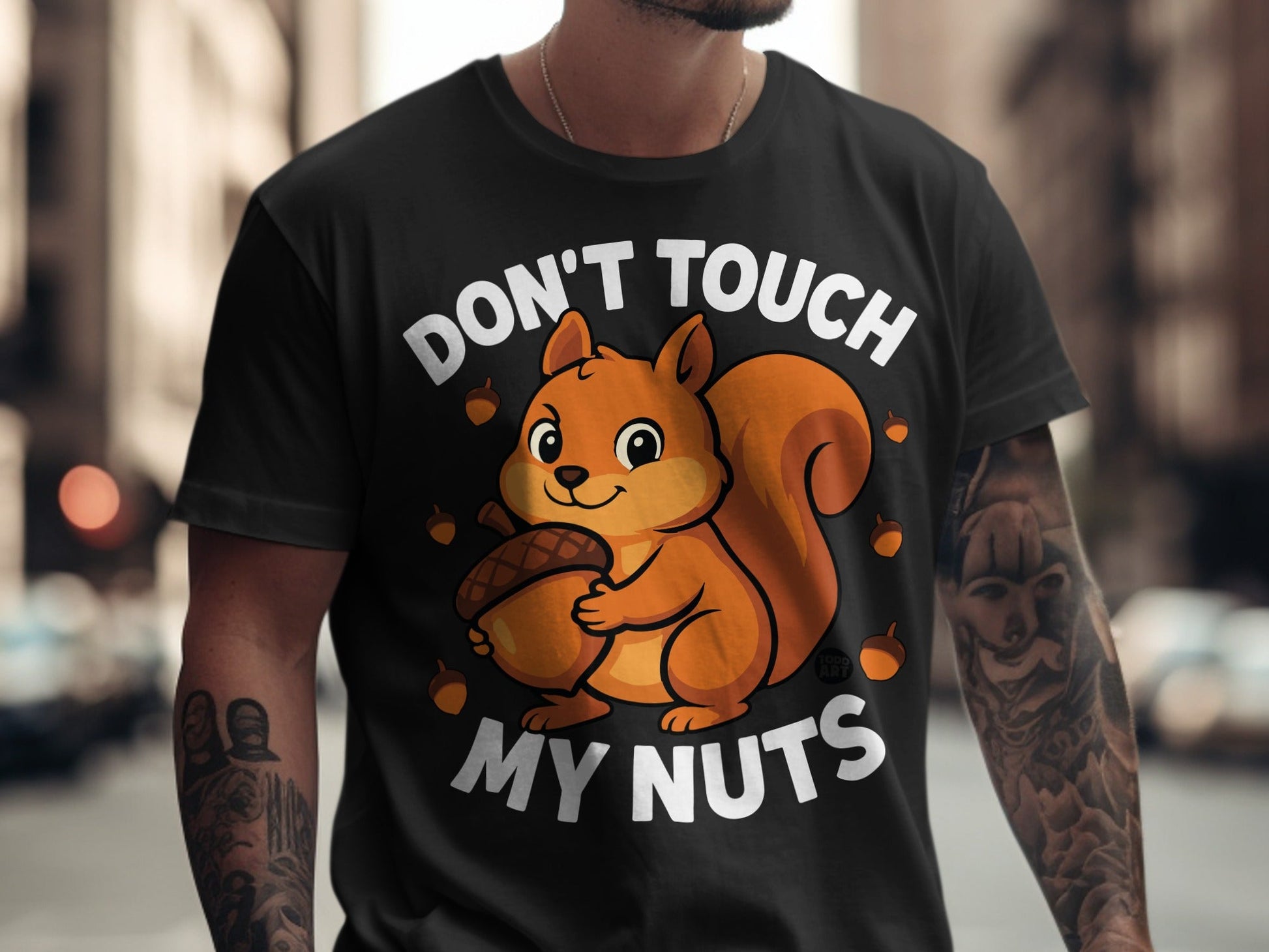 Black t-shirt with a cartoon squirrel holding an acorn and the text "DON'T TOUCH MY NUTS".