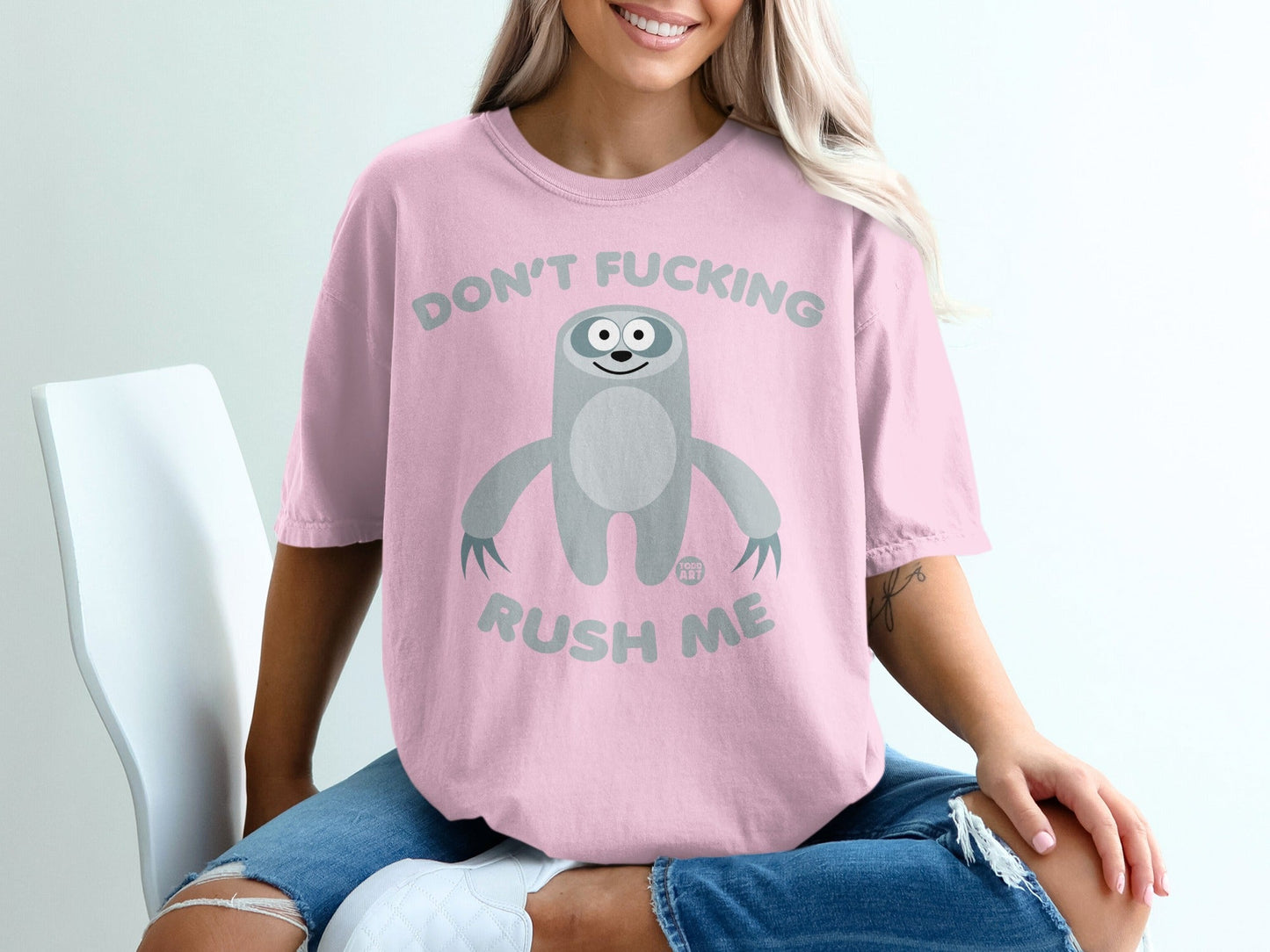 Pink t-shirt with a sloth graphic and text "DON'T FUCKING RUSH ME".