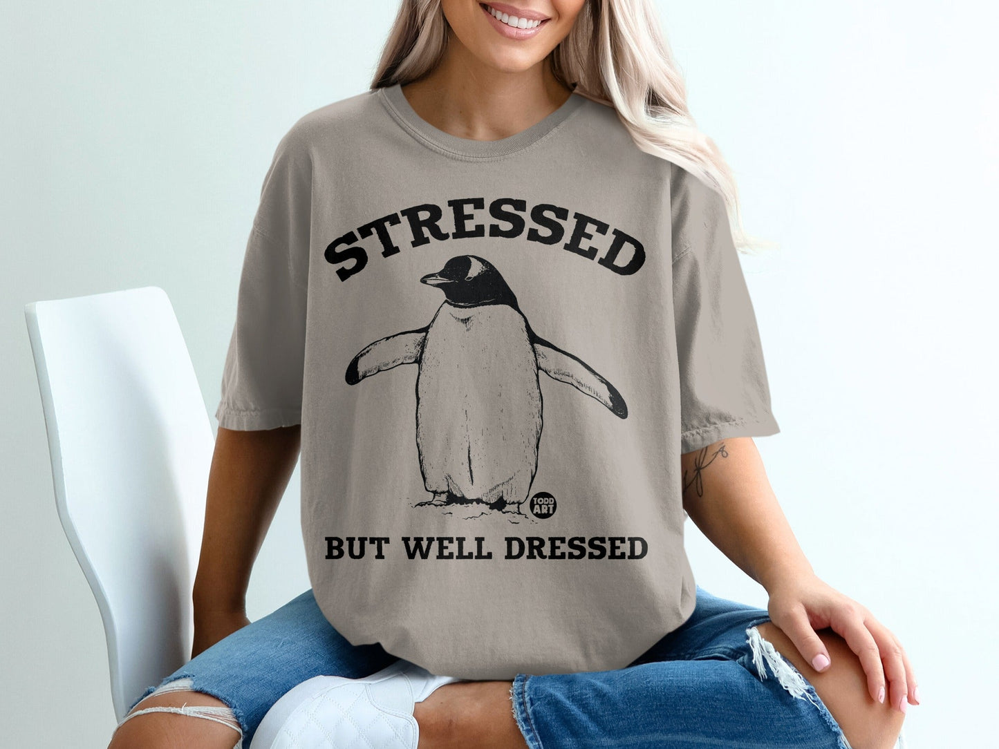 T-shirt with a penguin and text "STRESSED BUT WELL DRESSED".