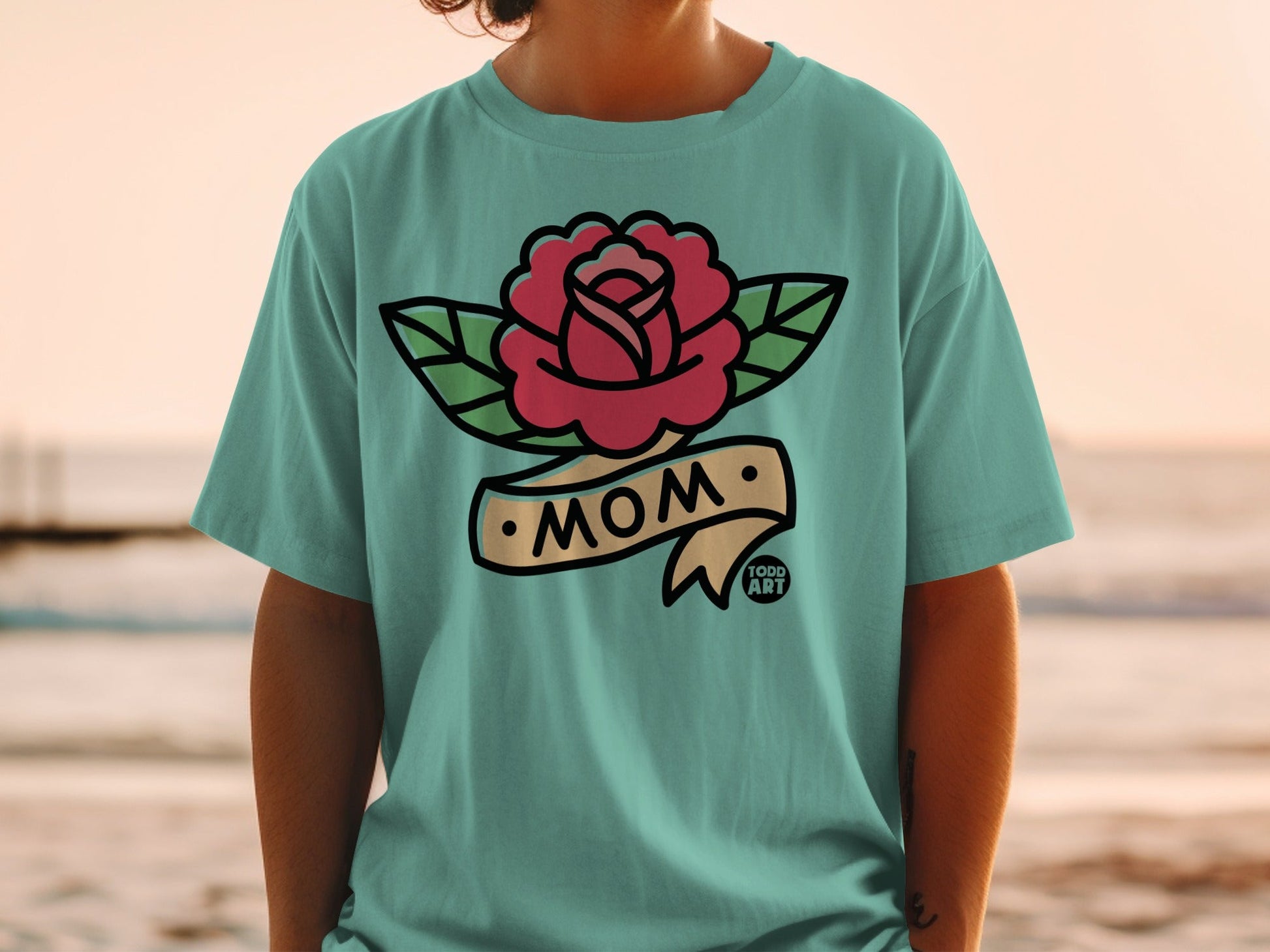 Teal t-shirt with a traditional tattoo-style rose and "MOM" banner design.