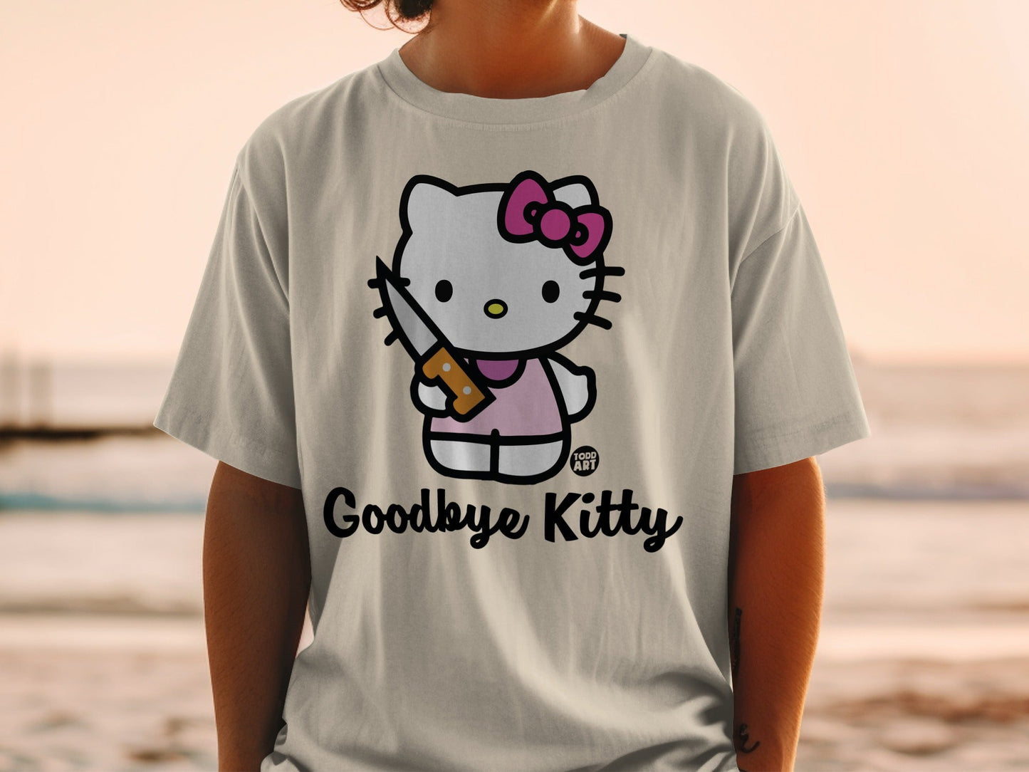Hello Kitty character in pink dress holding a knife on a t-shirt.