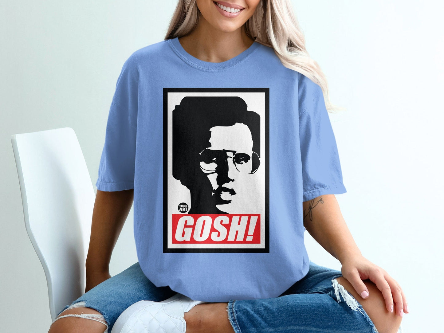 Light blue t-shirt with a black and white graphic of a man in glasses and the word "GOSH!"