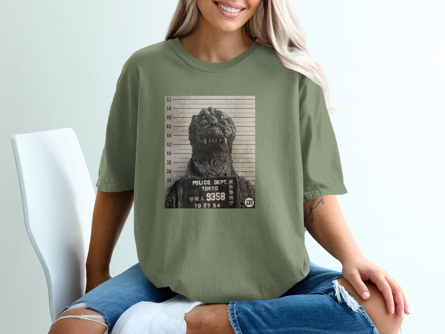 Green t-shirt with a mugshot of Godzilla, "Tokyo Police Dept" text.