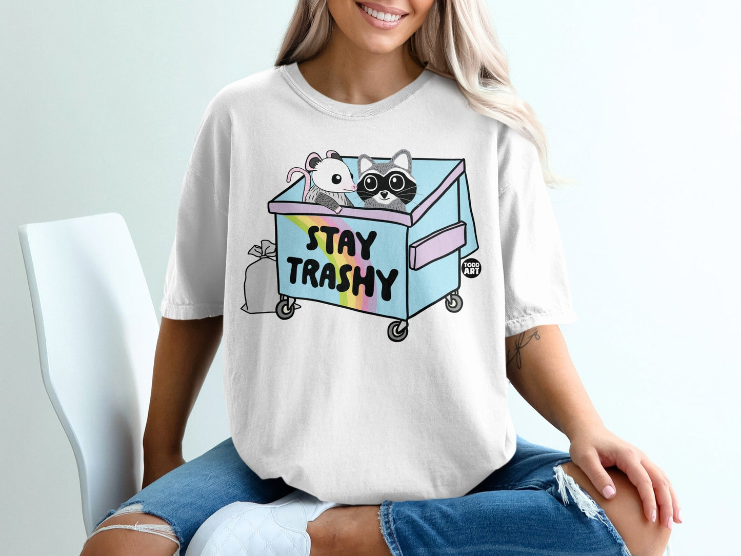 Trash can with raccoon and mouse, "Stay Trashy" text, rainbow accents.
