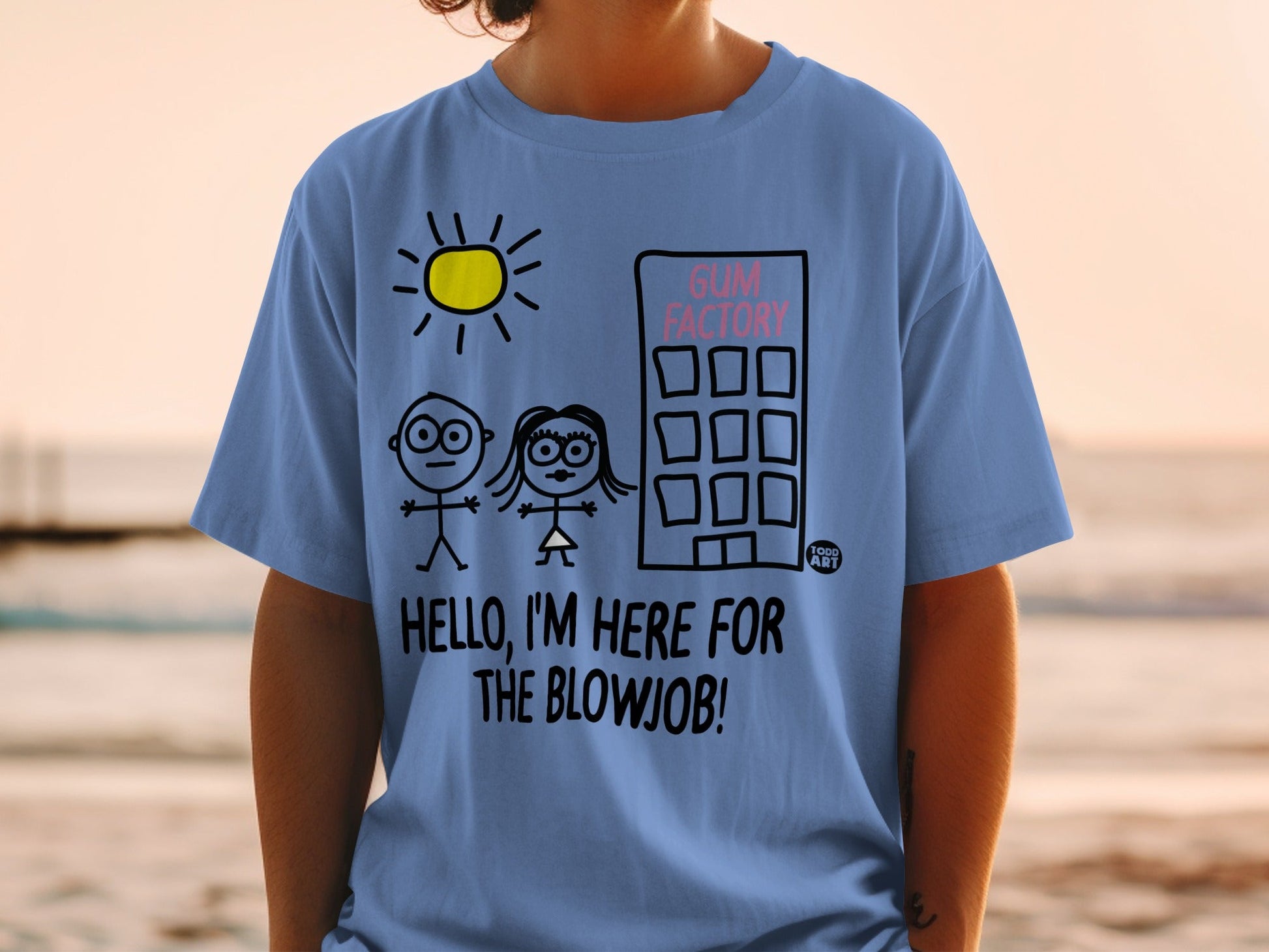 Blue t-shirt with stick figures, building, sun, and text "GUM FACTORY HELLO, I'M HERE FOR THE BLOWJOB!"