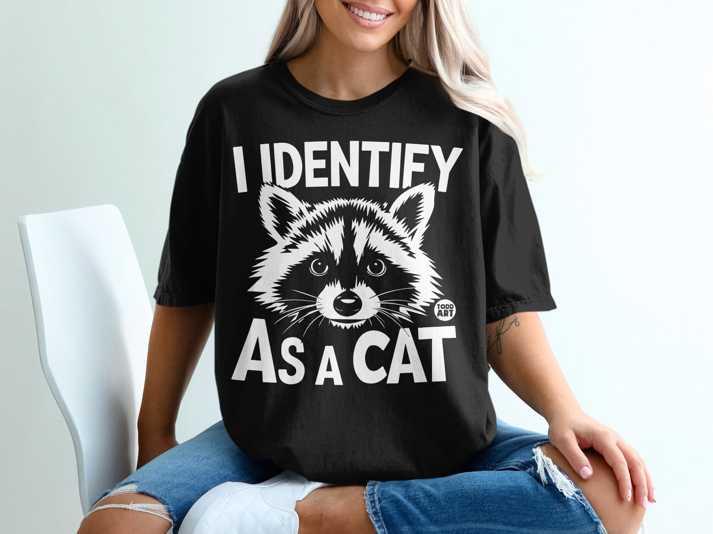 Black t-shirt with "I IDENTIFY AS A CAT" and a raccoon graphic.