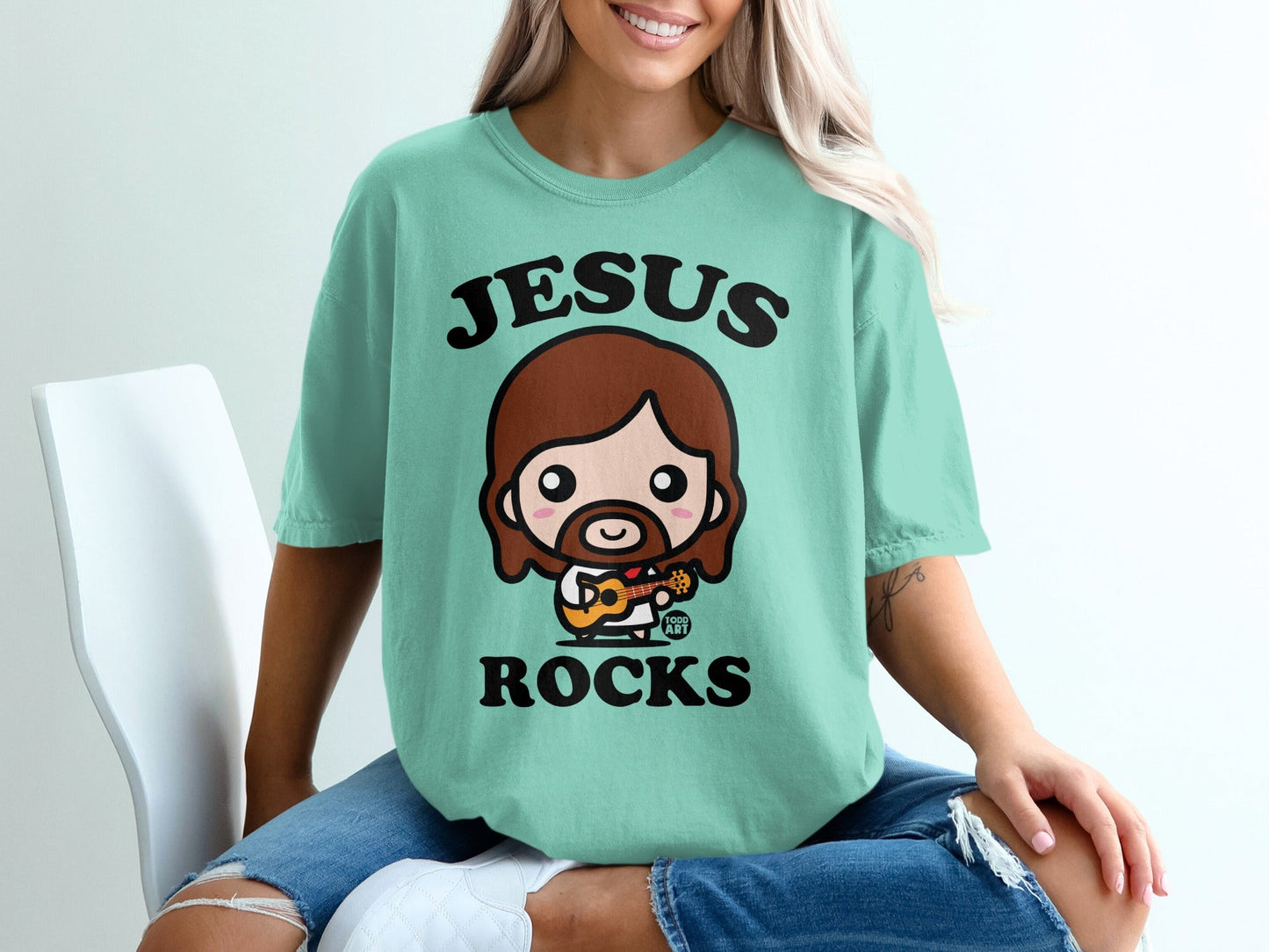 Mint t-shirt with cartoon Jesus playing guitar, text "JESUS ROCKS".