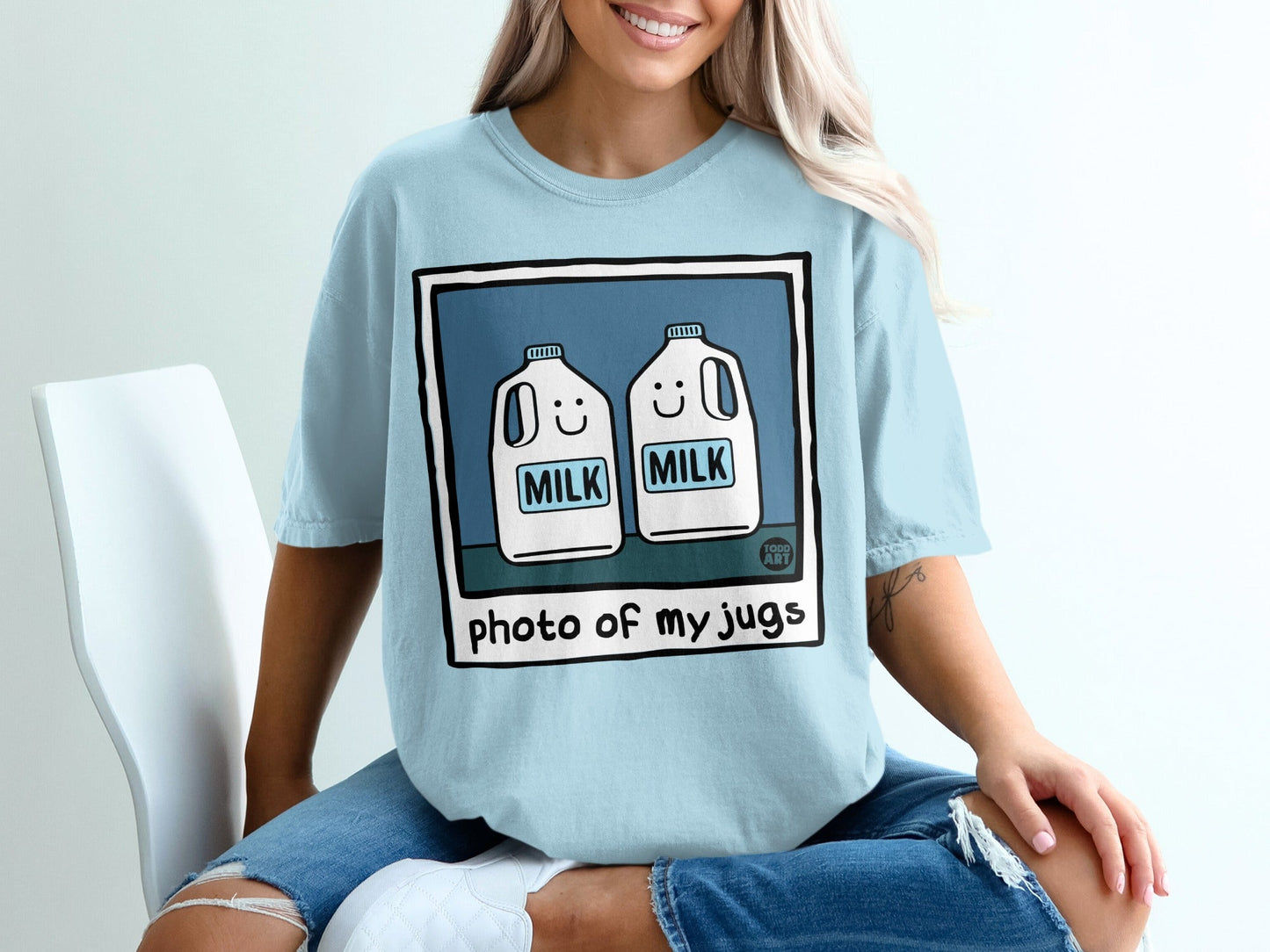 Light blue t-shirt with cartoon milk jugs that say "MILK".
