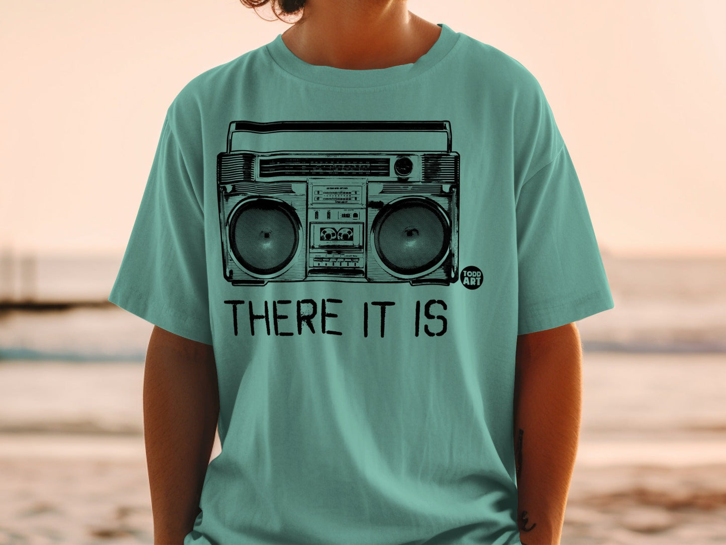 Teal t-shirt with graphic of vintage boombox and text "THERE IT IS".