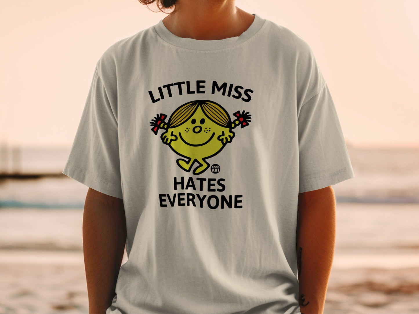 T-shirt with "Little Miss Hates Everyone" slogan and cartoon character.