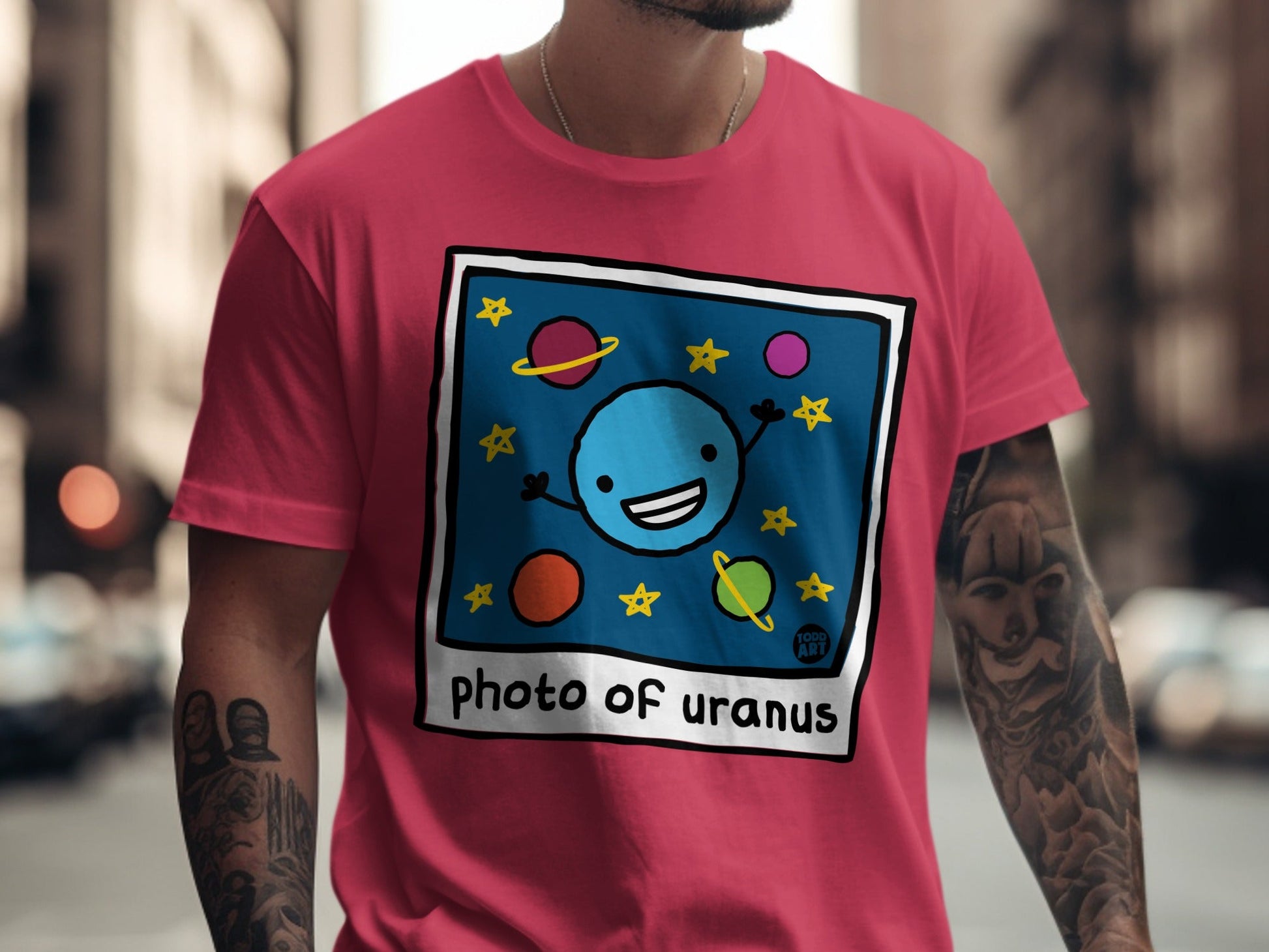 Blue planet character with arms and legs on a t-shirt, surrounded by stars.