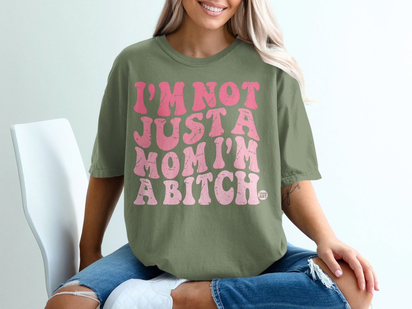 Olive green t-shirt with pink text that reads "I'm not just a mom, I'm a bitch."