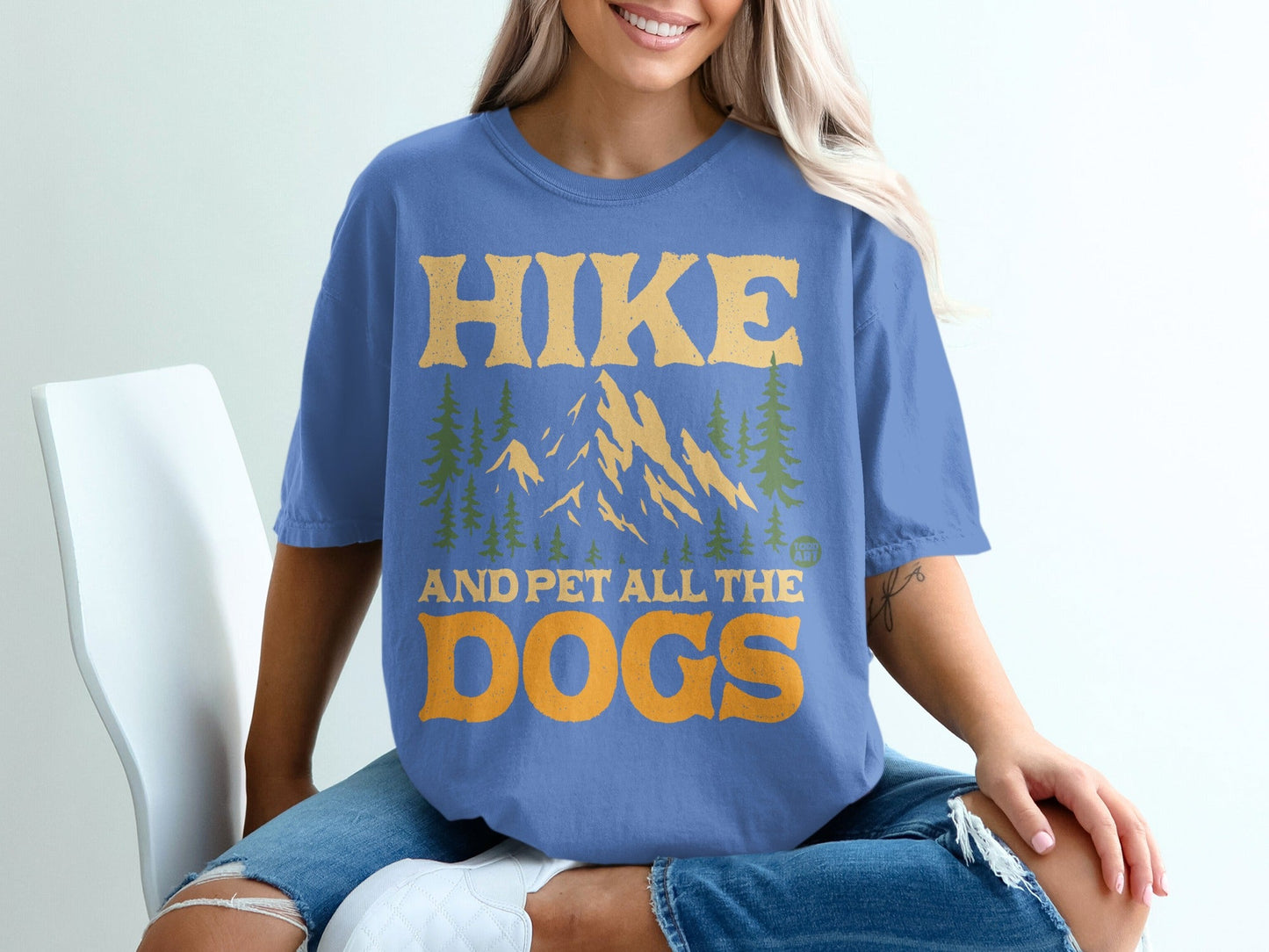Blue t-shirt with "Hike and pet all the dogs" text and mountain graphic.