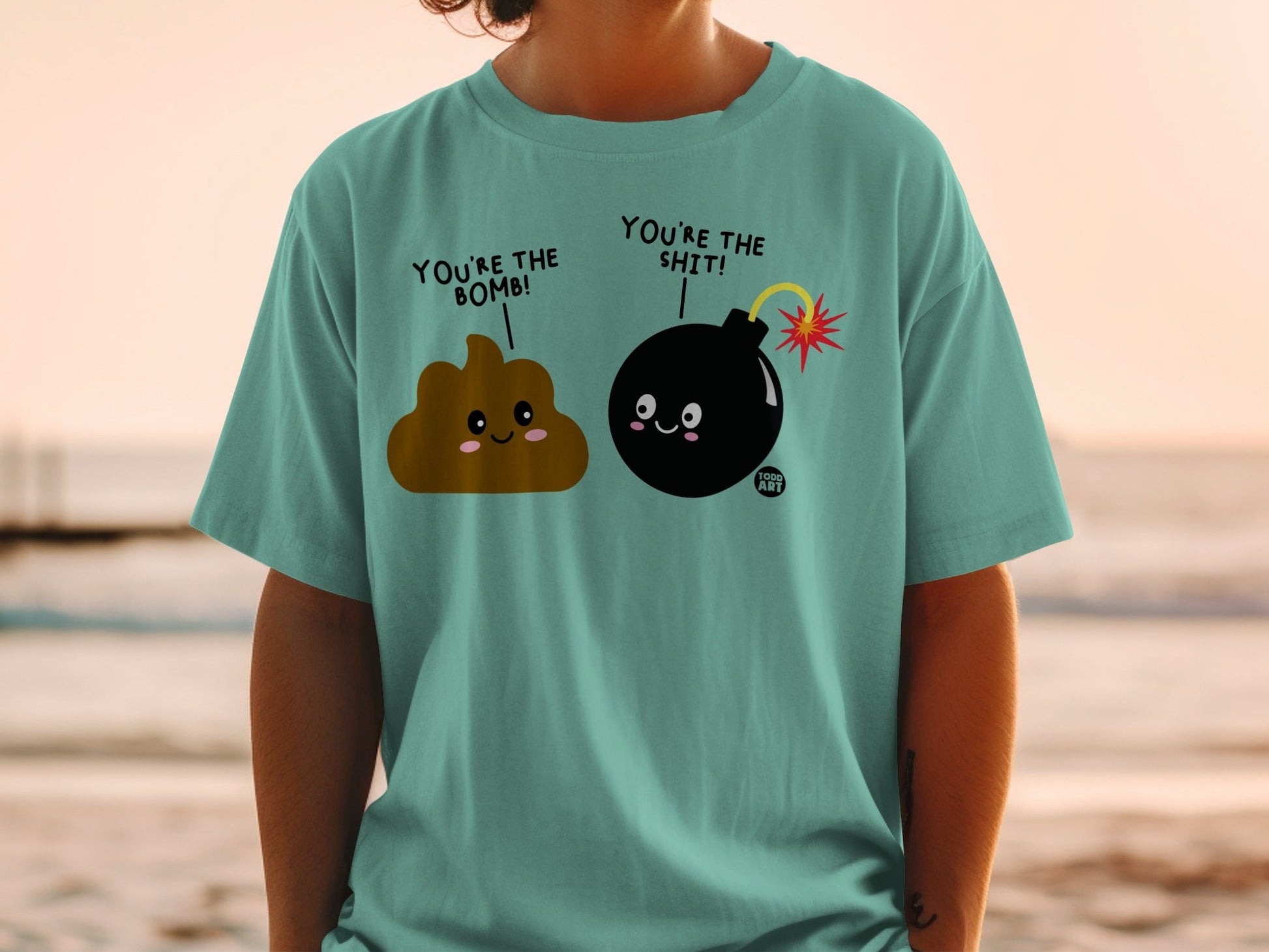 T-shirt featuring smiling poop and bomb characters with text.