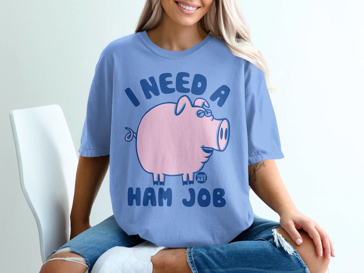 Light blue t-shirt with a pink cartoon pig and text "I NEED A HAM JOB".