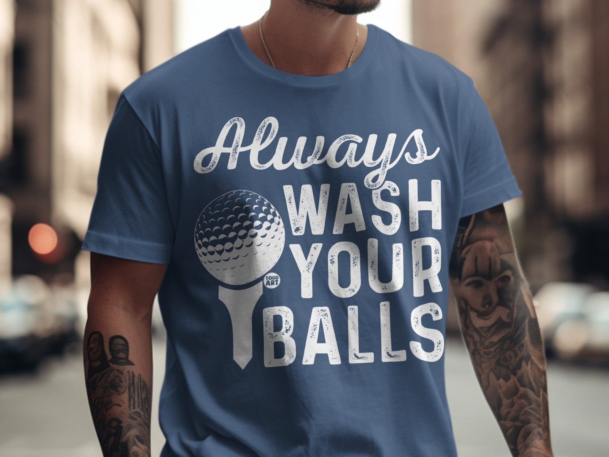 Blue t-shirt with white text and golf ball graphic: "Always WASH YOUR BALLS".