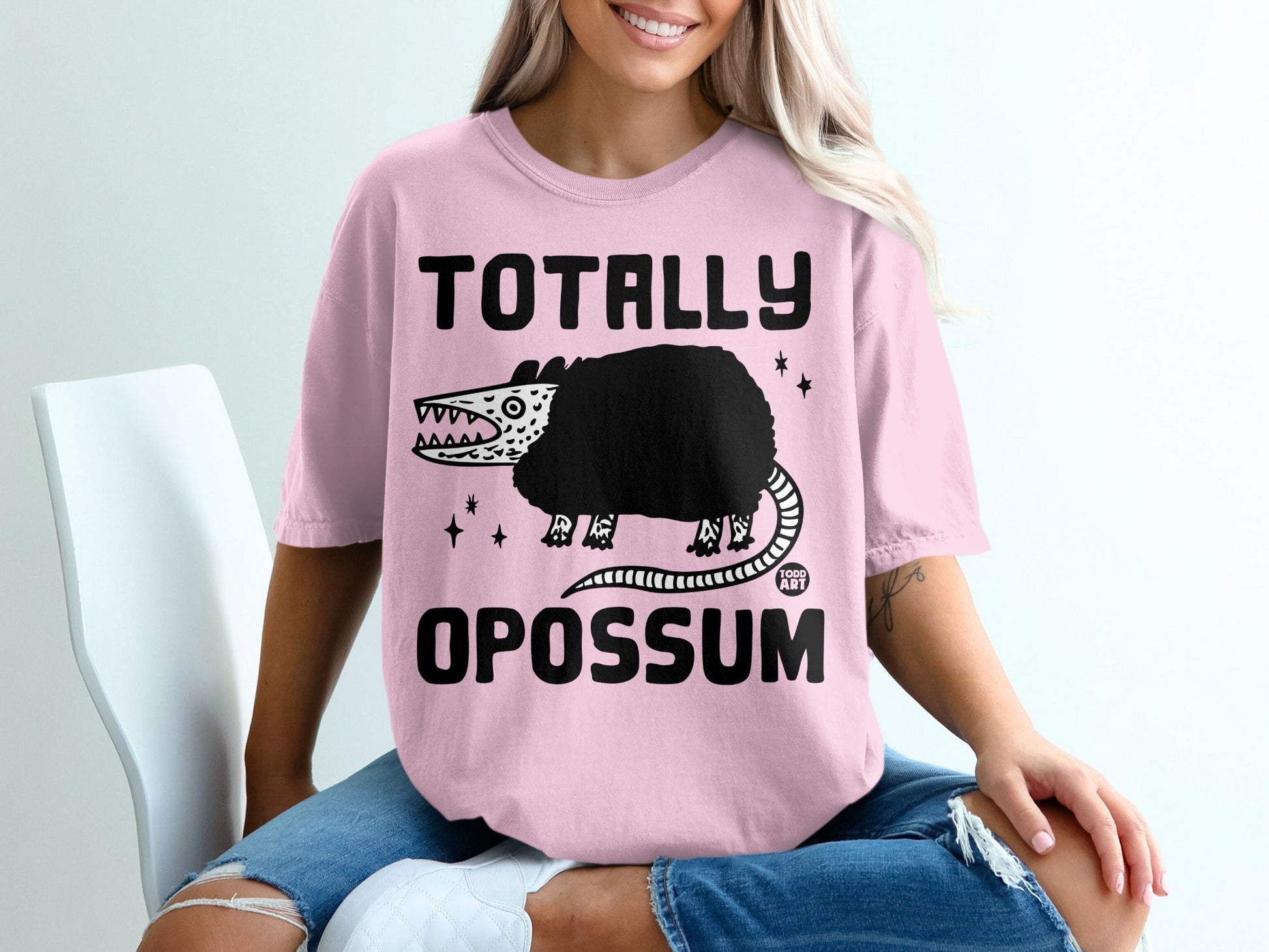 Pink t-shirt with "TOTALLY OPOSSUM" text and a cartoon opossum.