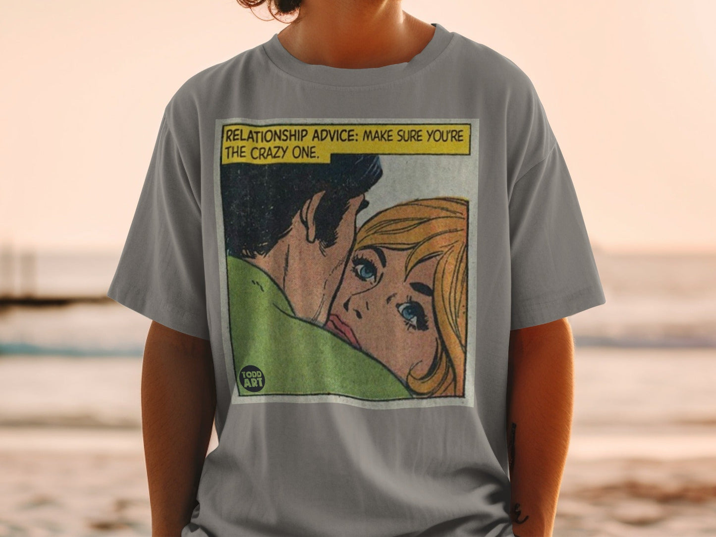 Gray t-shirt with comic panel illustration of a couple, "Relationship Advice: Make Sure You're the Crazy One."