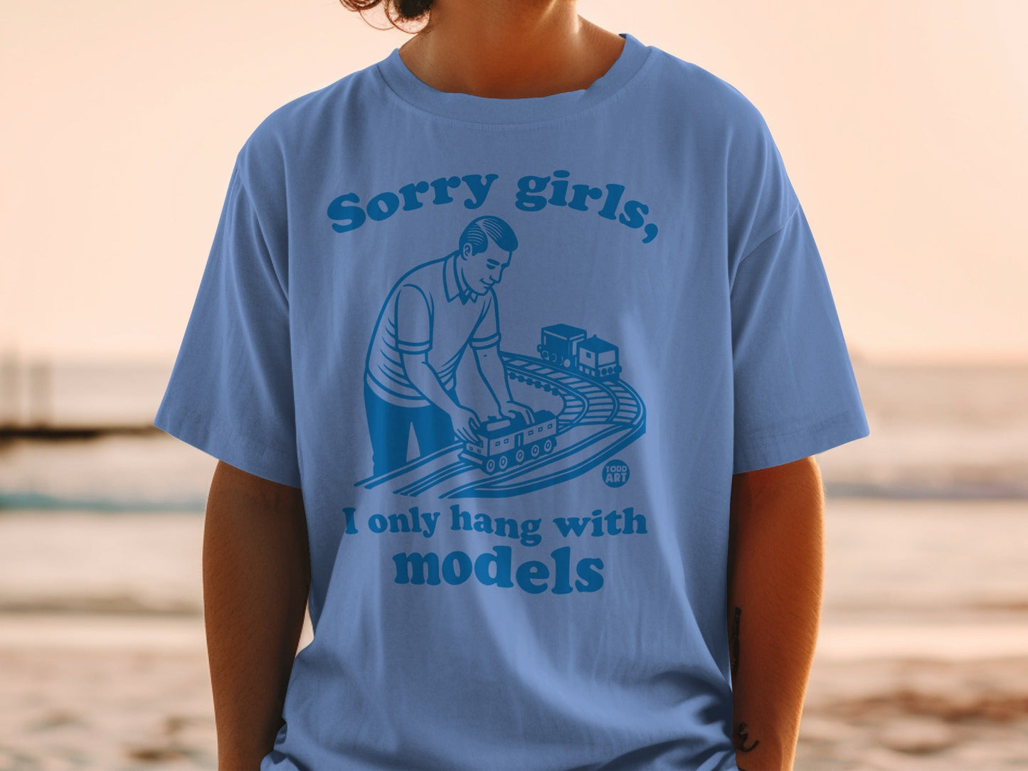 Blue t-shirt with graphic of man and toy train, text "Sorry girls, I only hang with models".