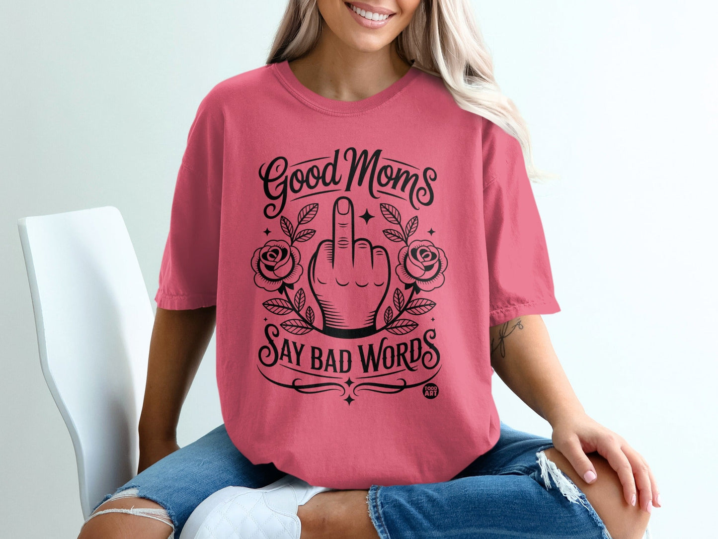 Pink t-shirt with "Good Moms Say Bad Words" graphic and floral accents.