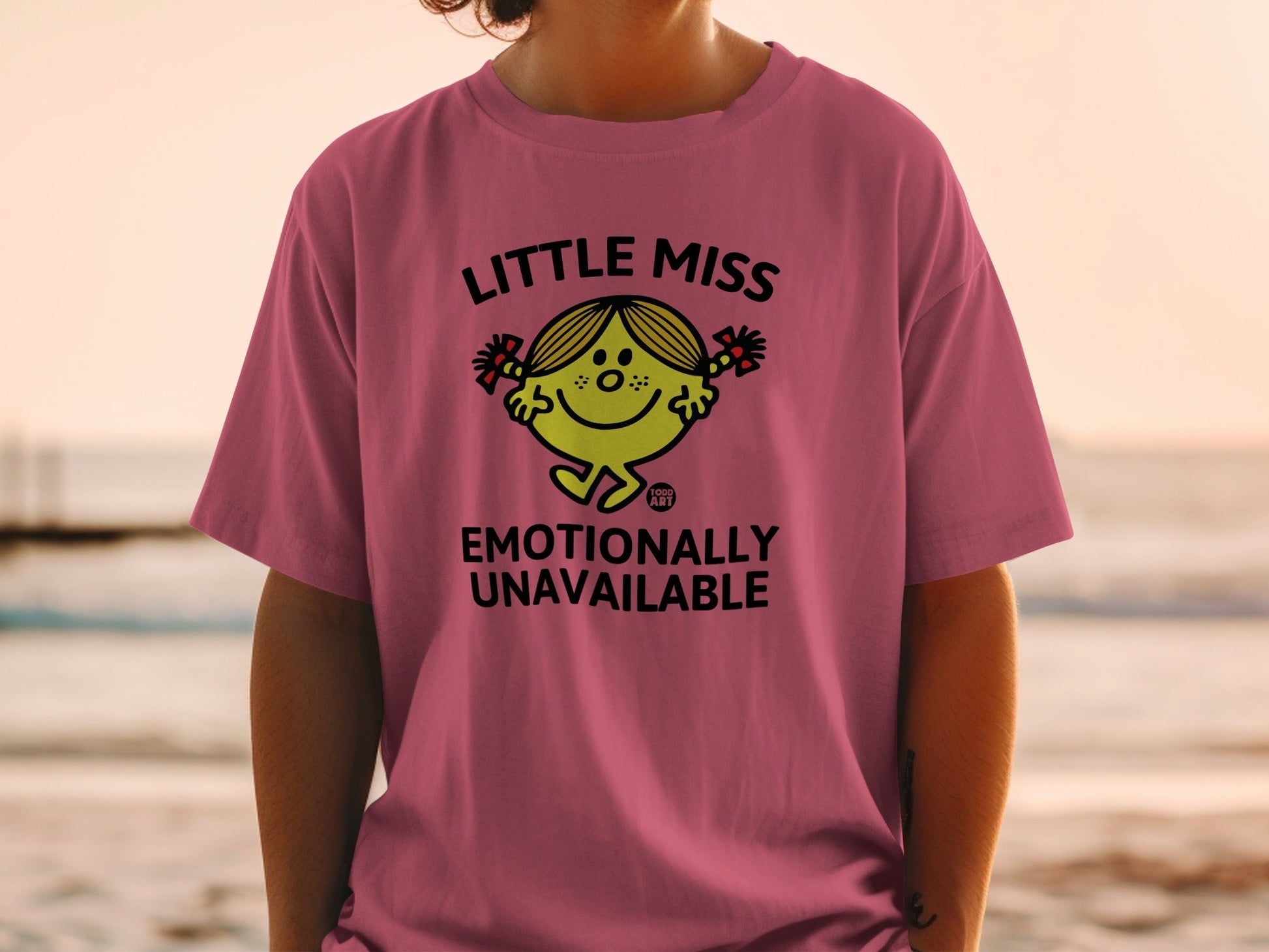 Pink t-shirt with "Little Miss Emotionally Unavailable" text and cartoon character.