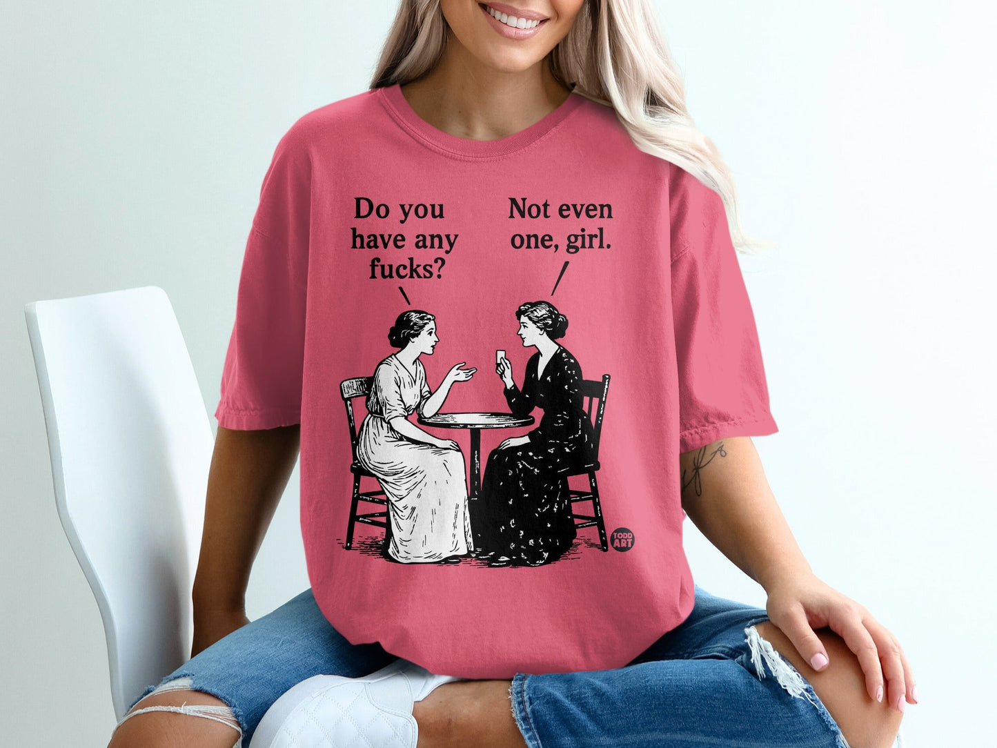 Two women seated at a table, one asks "Do you have any fucks?" the other replies "Not even one, girl."
