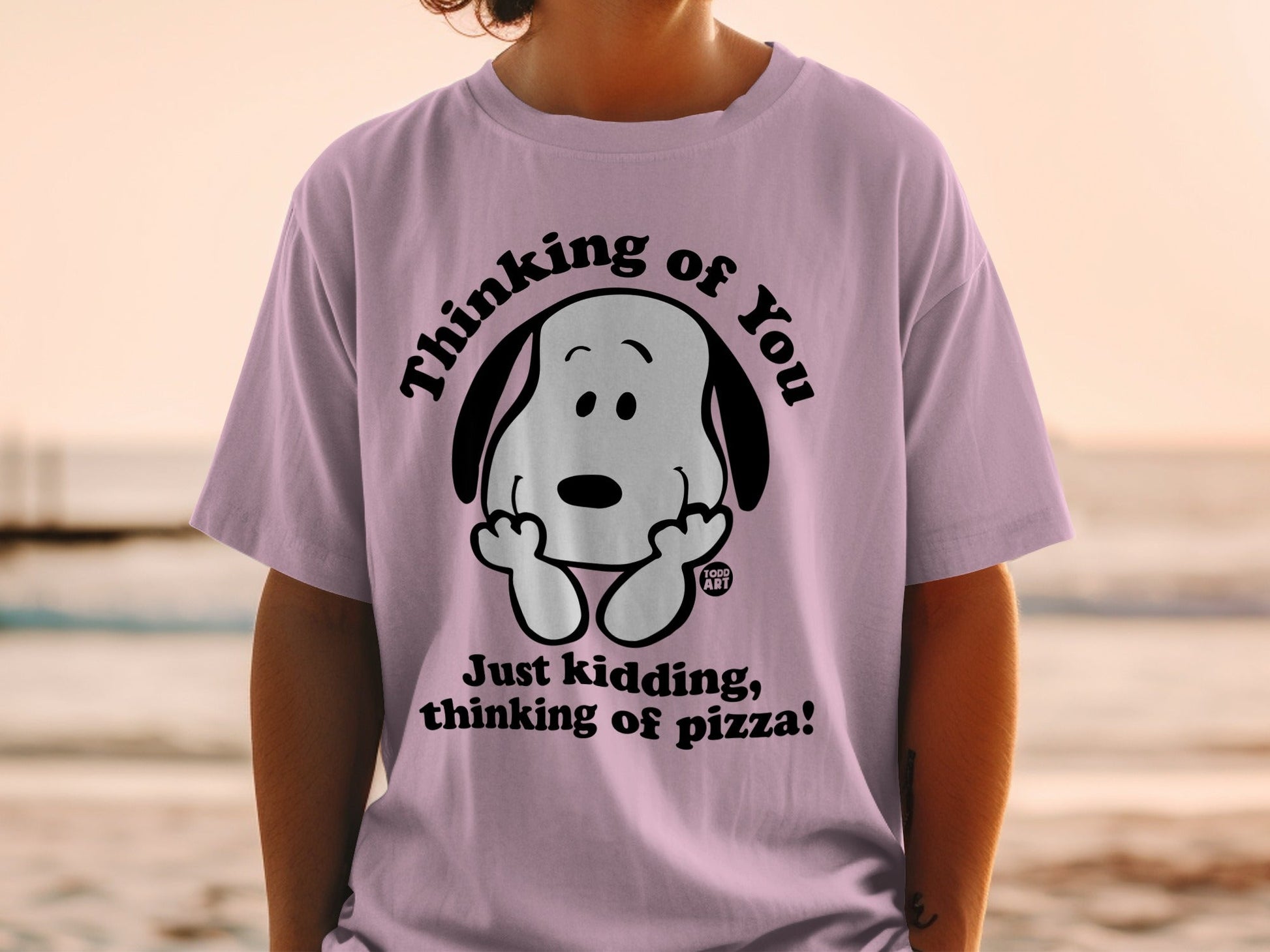 Pink t-shirt with Snoopy saying "Just kidding, thinking of pizza!"