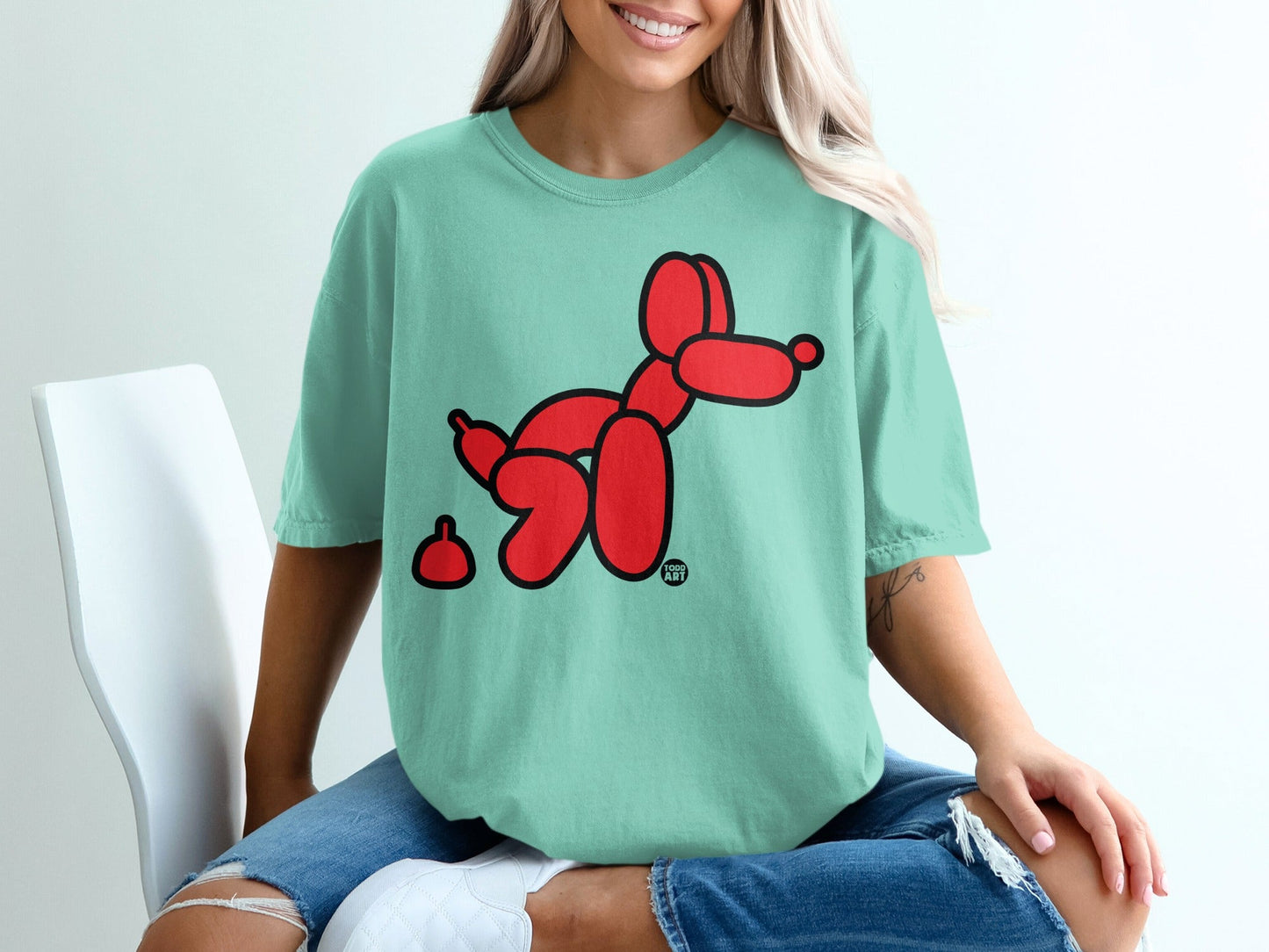Mint green t-shirt with red balloon dog and abstract red dot graphic.