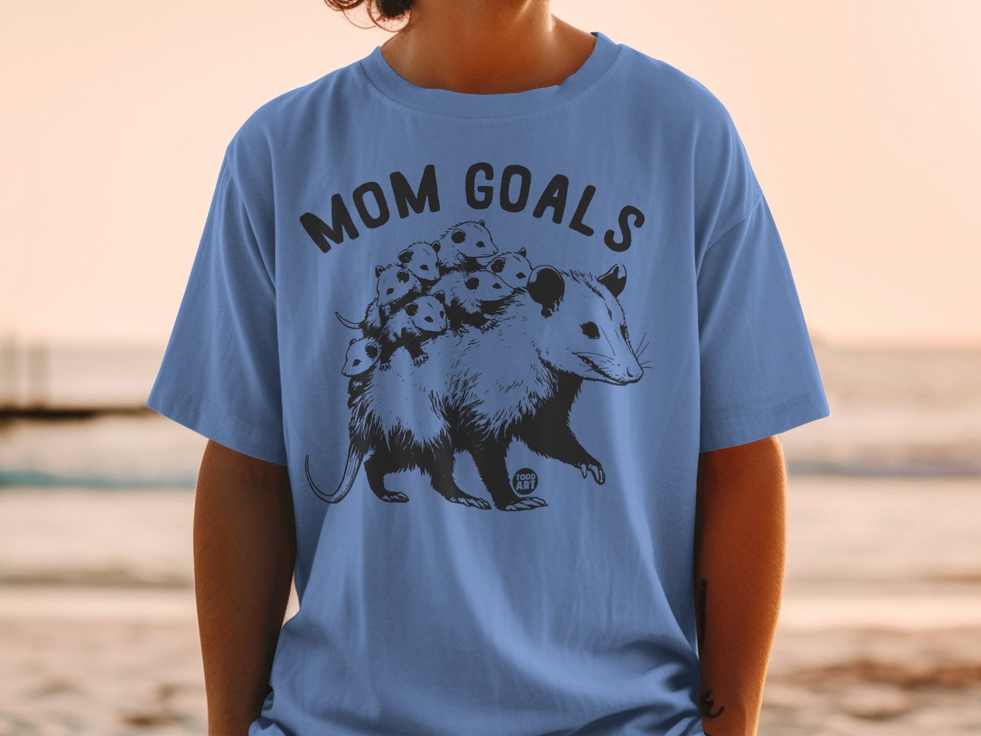 Opossum with babies on its back and "Mom Goals" text.