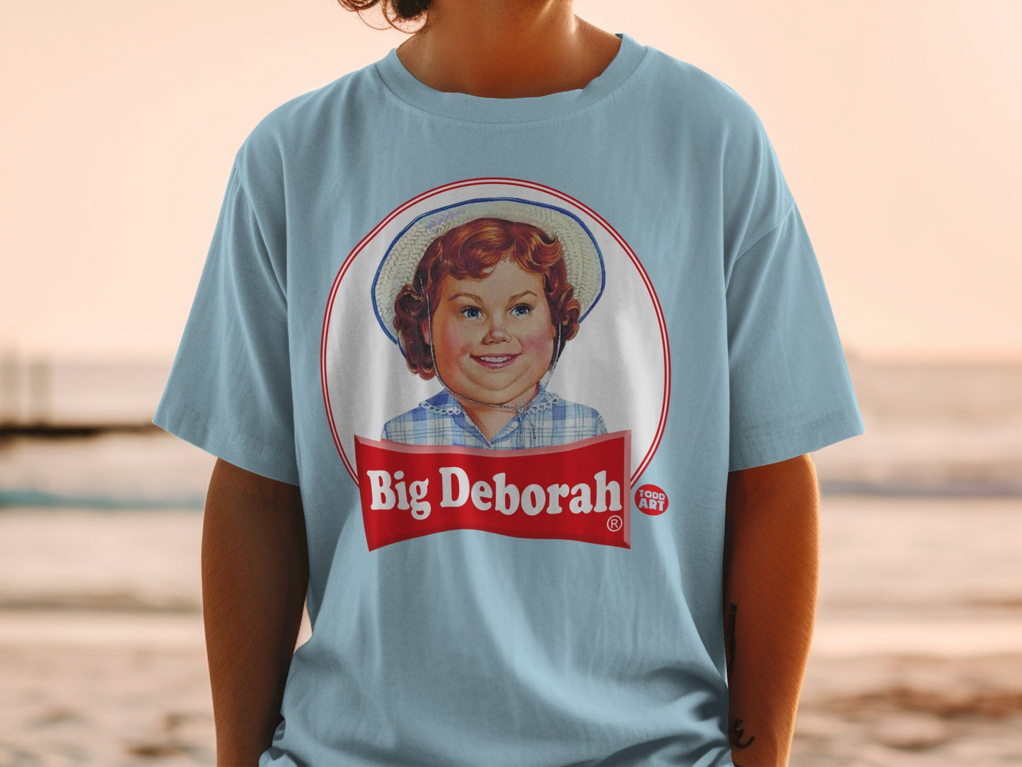 Light blue t-shirt with "Big Deborah" logo featuring a smiling girl.