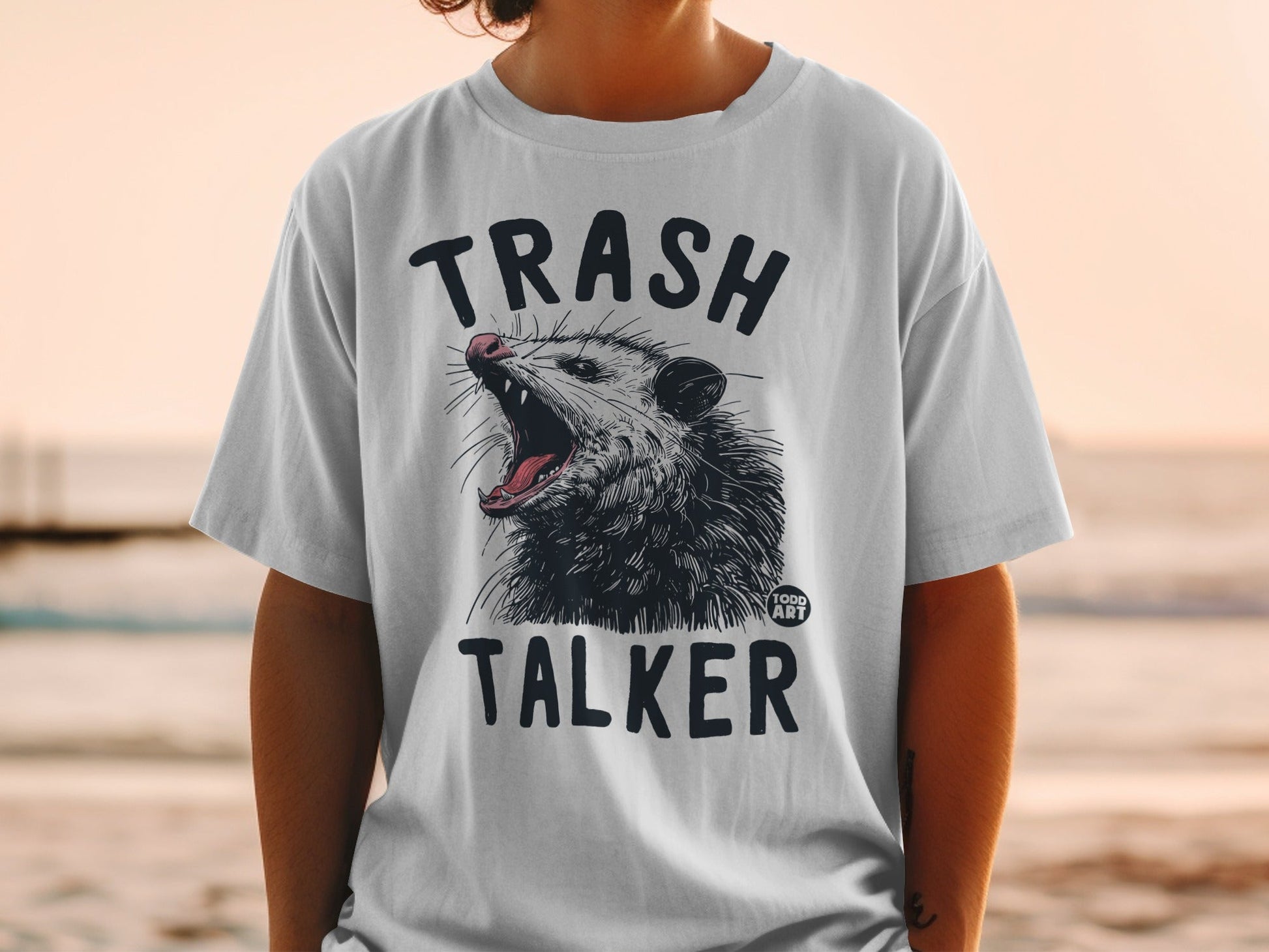 White t-shirt with "TRASH TALKER" and a graphic of an opossum with its mouth open.