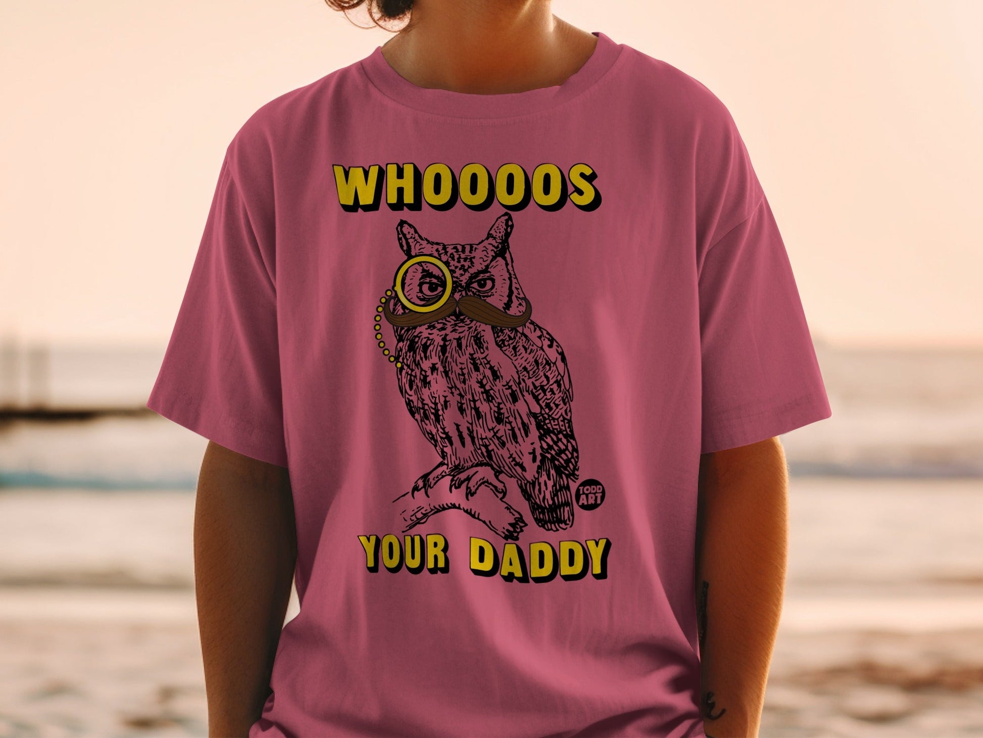 Pink t-shirt with owl wearing monocle and mustache, text reads "Whooo's Your Daddy".
