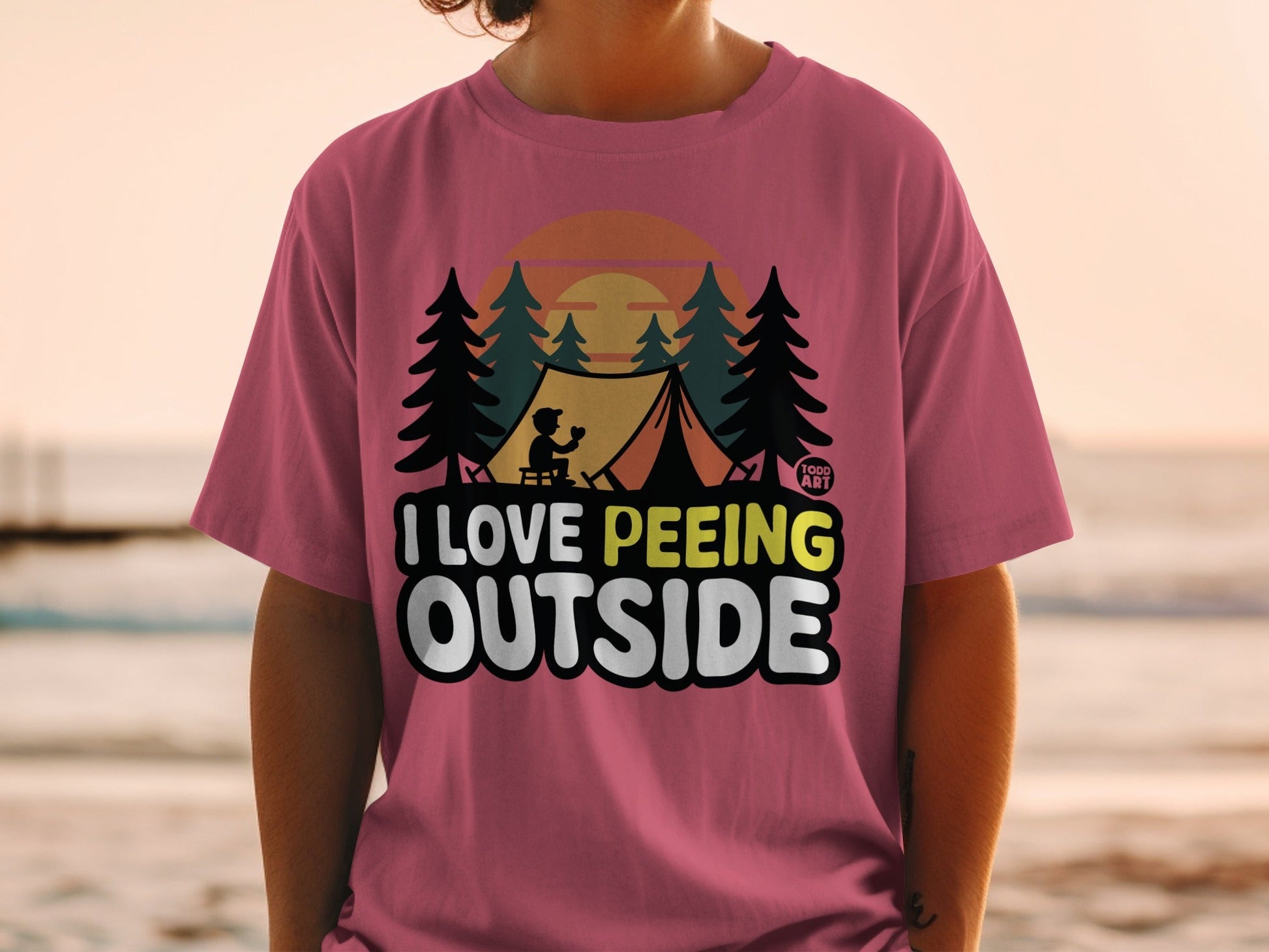 Pink t-shirt with "I Love Peeing Outside" text and camping graphic.