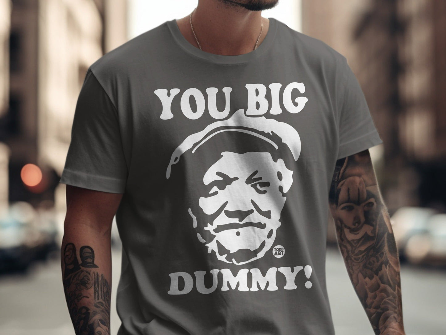 Grey t-shirt with "YOU BIG DUMMY!" and a man's face in white print.