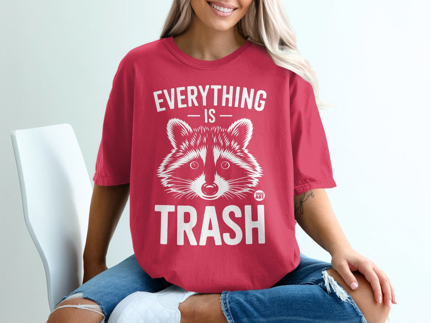 Red t-shirt with raccoon graphic and text "EVERYTHING IS TRASH".