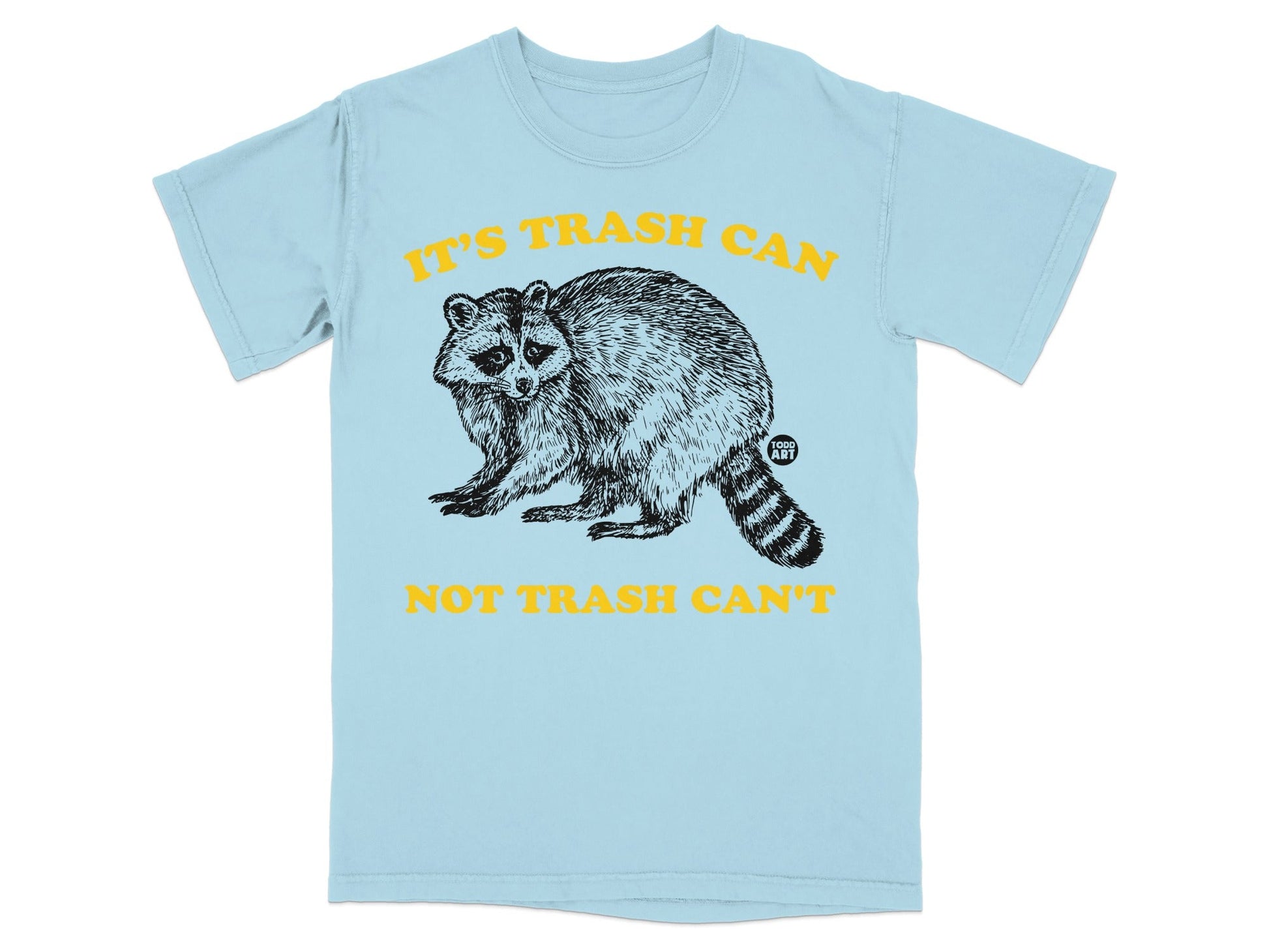 Light blue t-shirt with black raccoon graphic and yellow text "IT'S TRASH CAN NOT TRASH CAN'T".