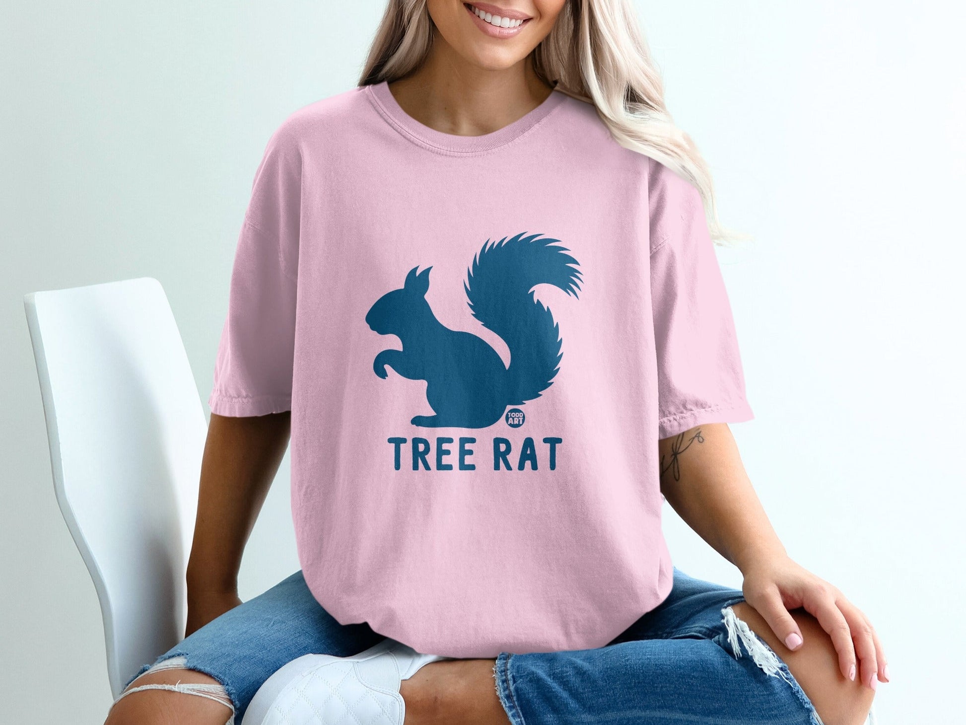 Pink t-shirt with a blue squirrel graphic and the words "TREE RAT".