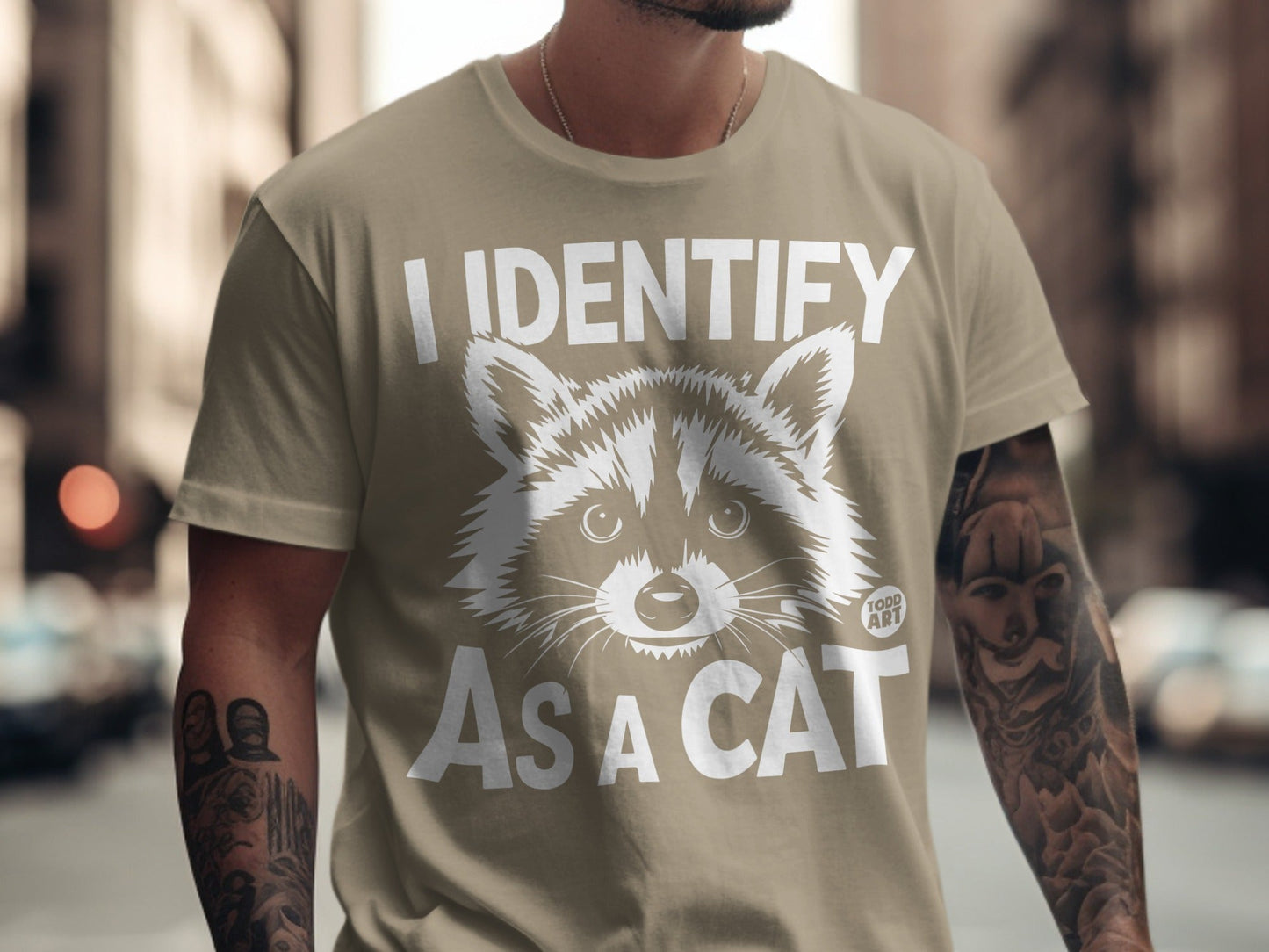 T-shirt with "I identify as a cat" and a raccoon face graphic.