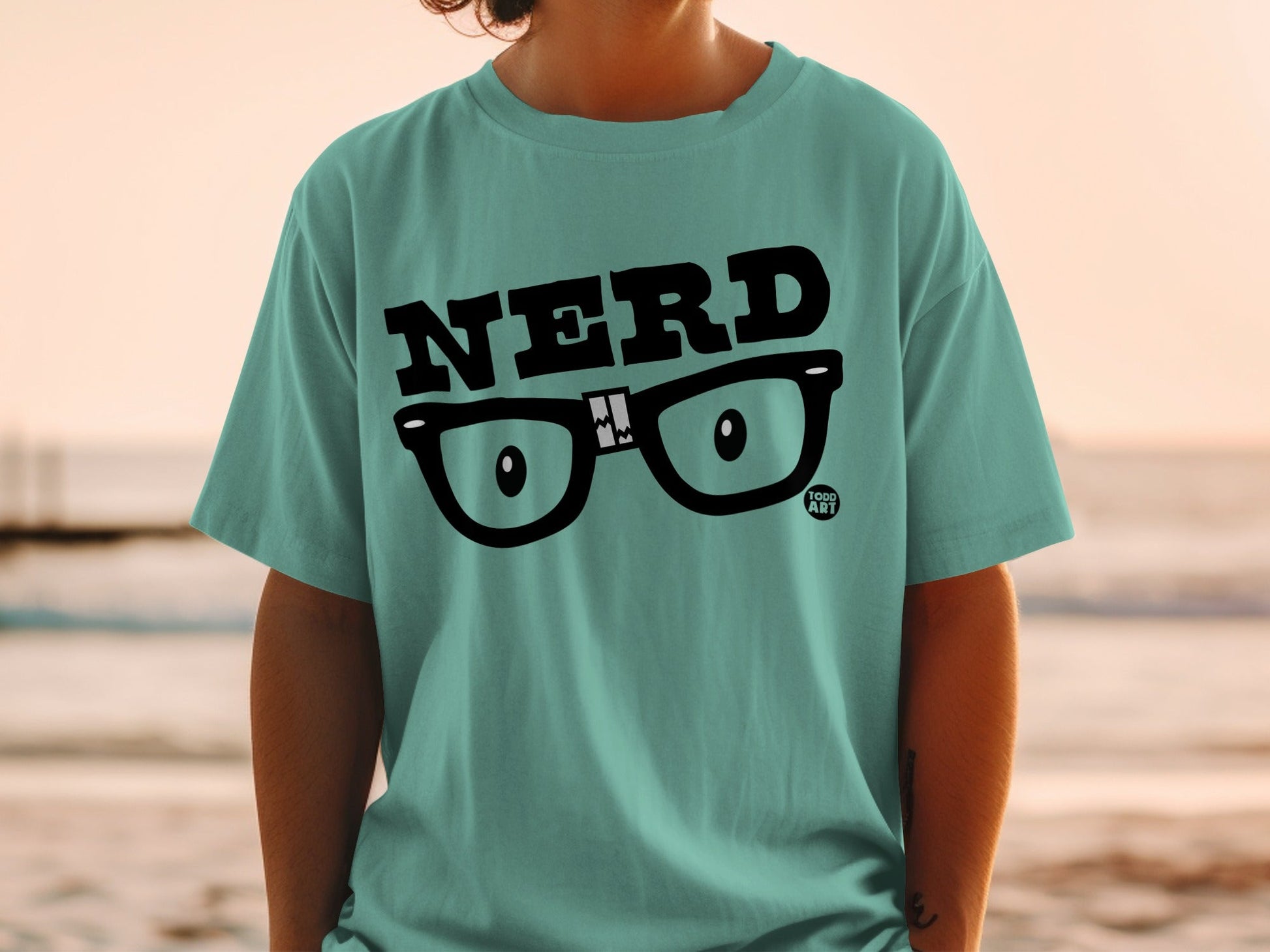 Teal t-shirt with "NERD" text and glasses graphic.