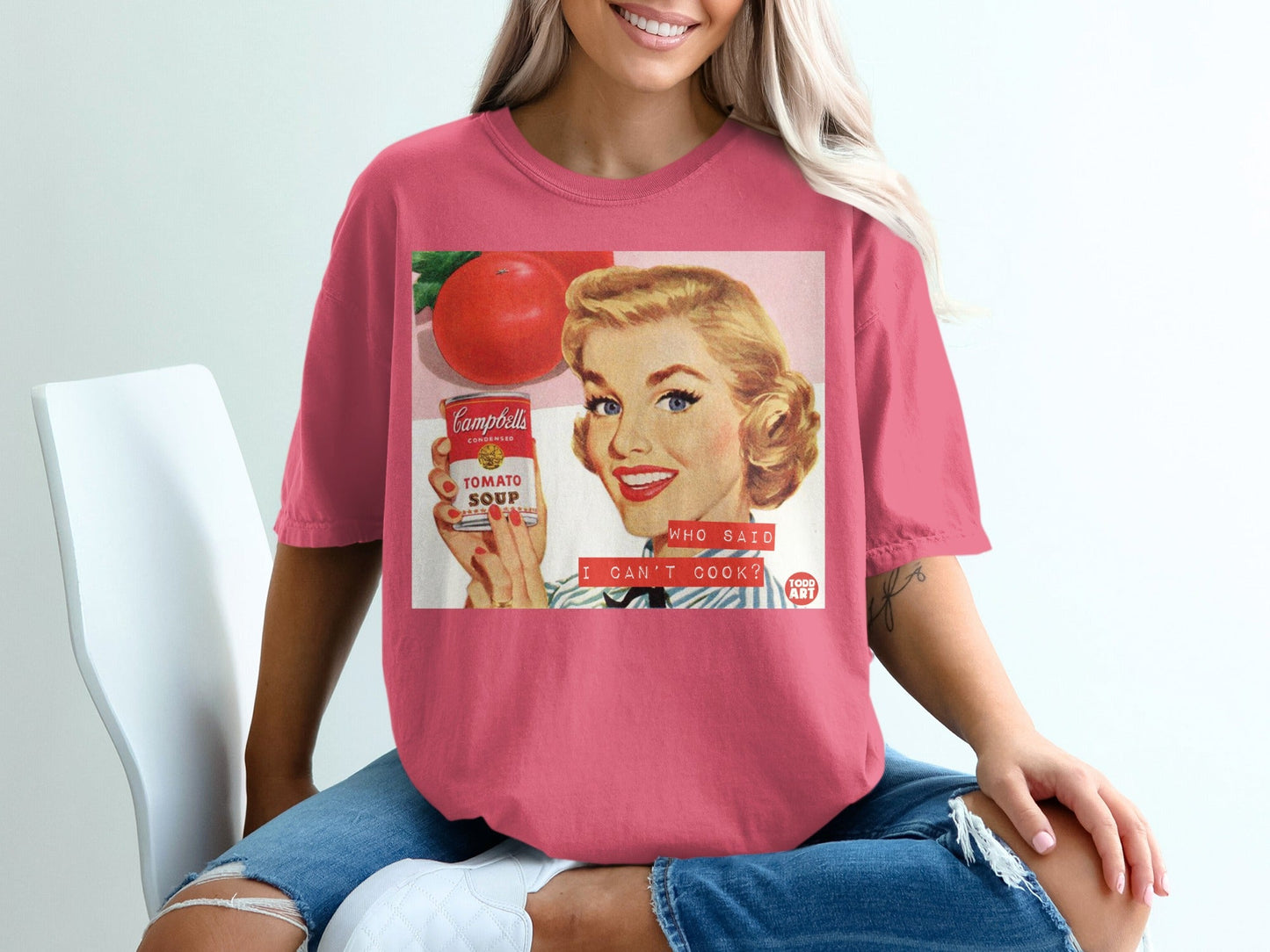 Woman wearing a t-shirt featuring a retro Campbell's Tomato Soup can ad.