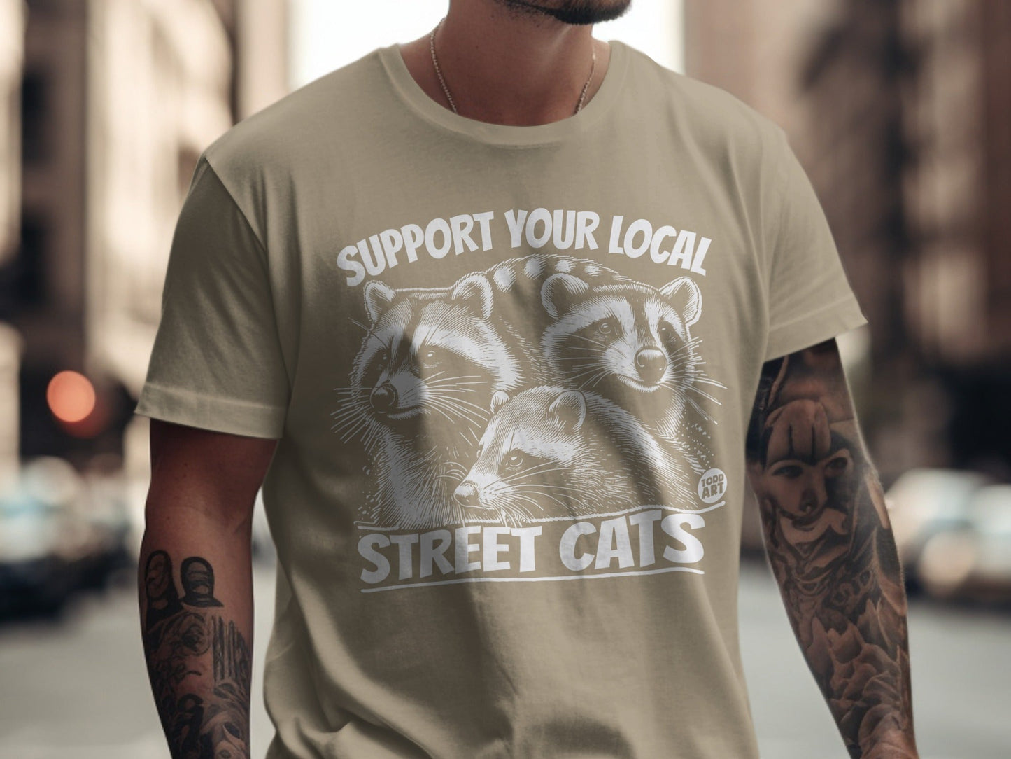 T-shirt with "SUPPORT YOUR LOCAL STREET CATS" and raccoon graphic.