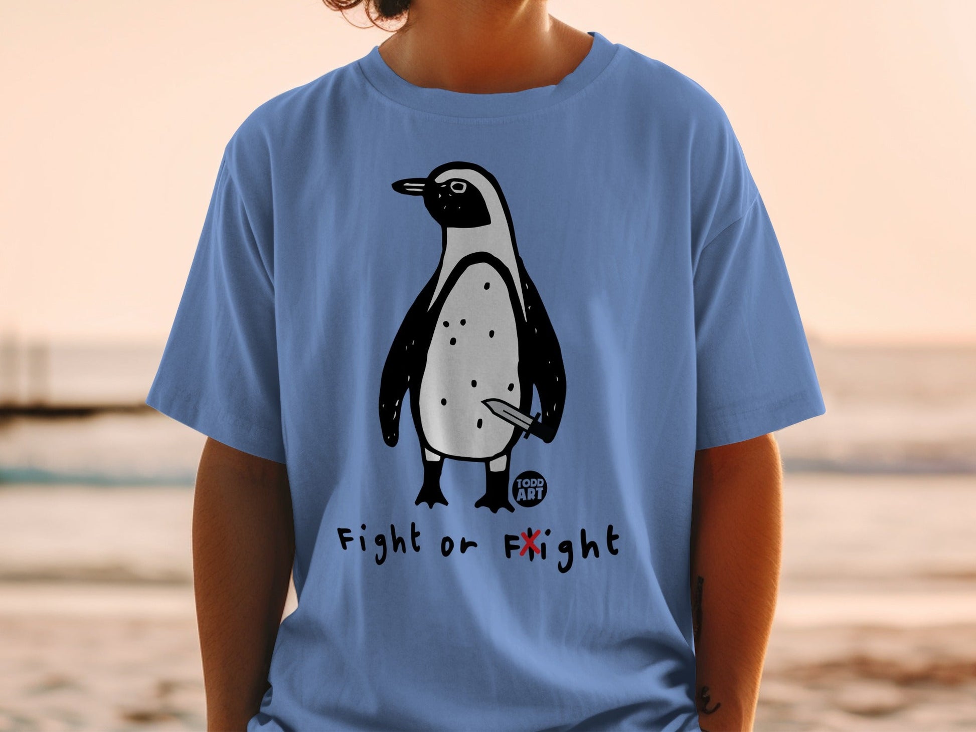 Penguin with knife graphic on blue t-shirt, text "FIGHT or FLIGHT".