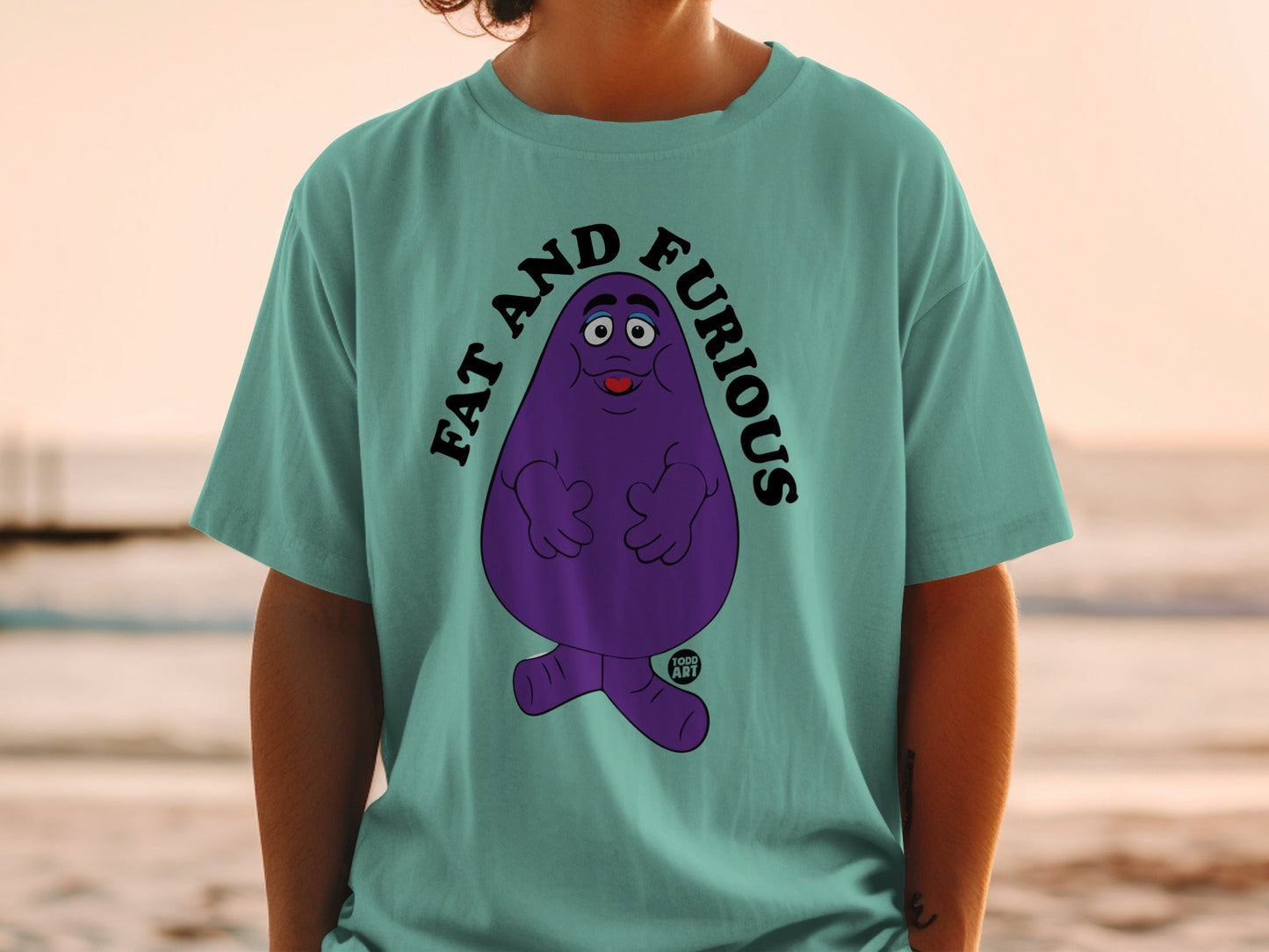 Teal t-shirt with Grimace from McDonald's saying "FAT AND FURIOUS".