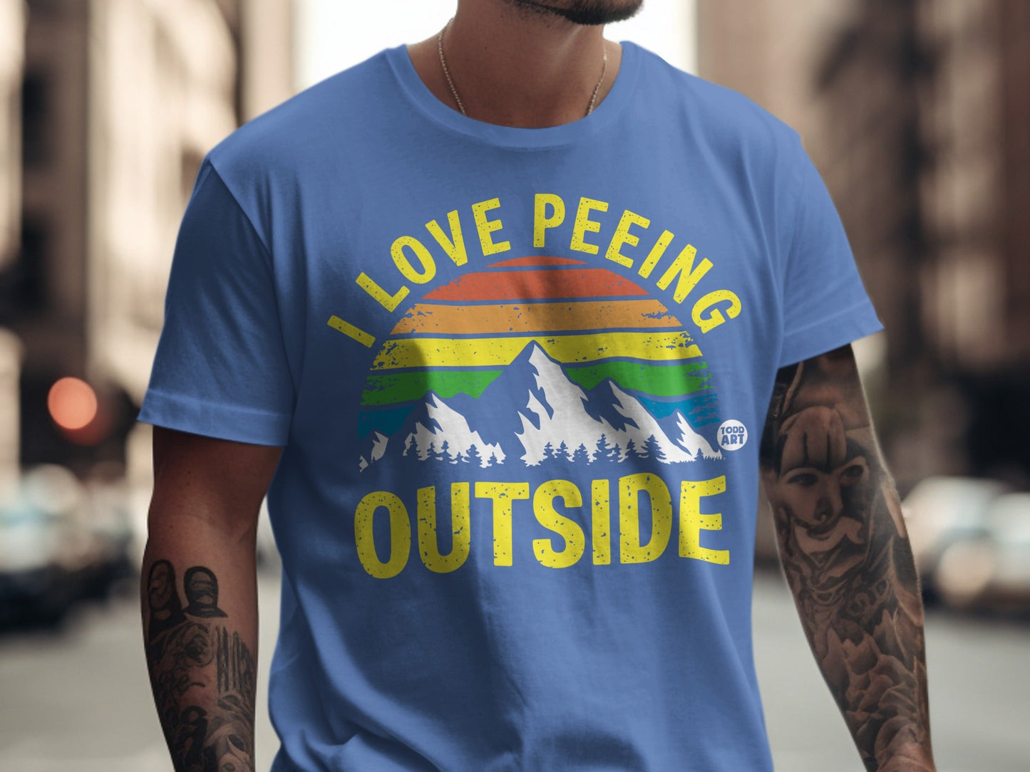 Blue t-shirt with "I love peeing outside" and rainbow mountain graphic.