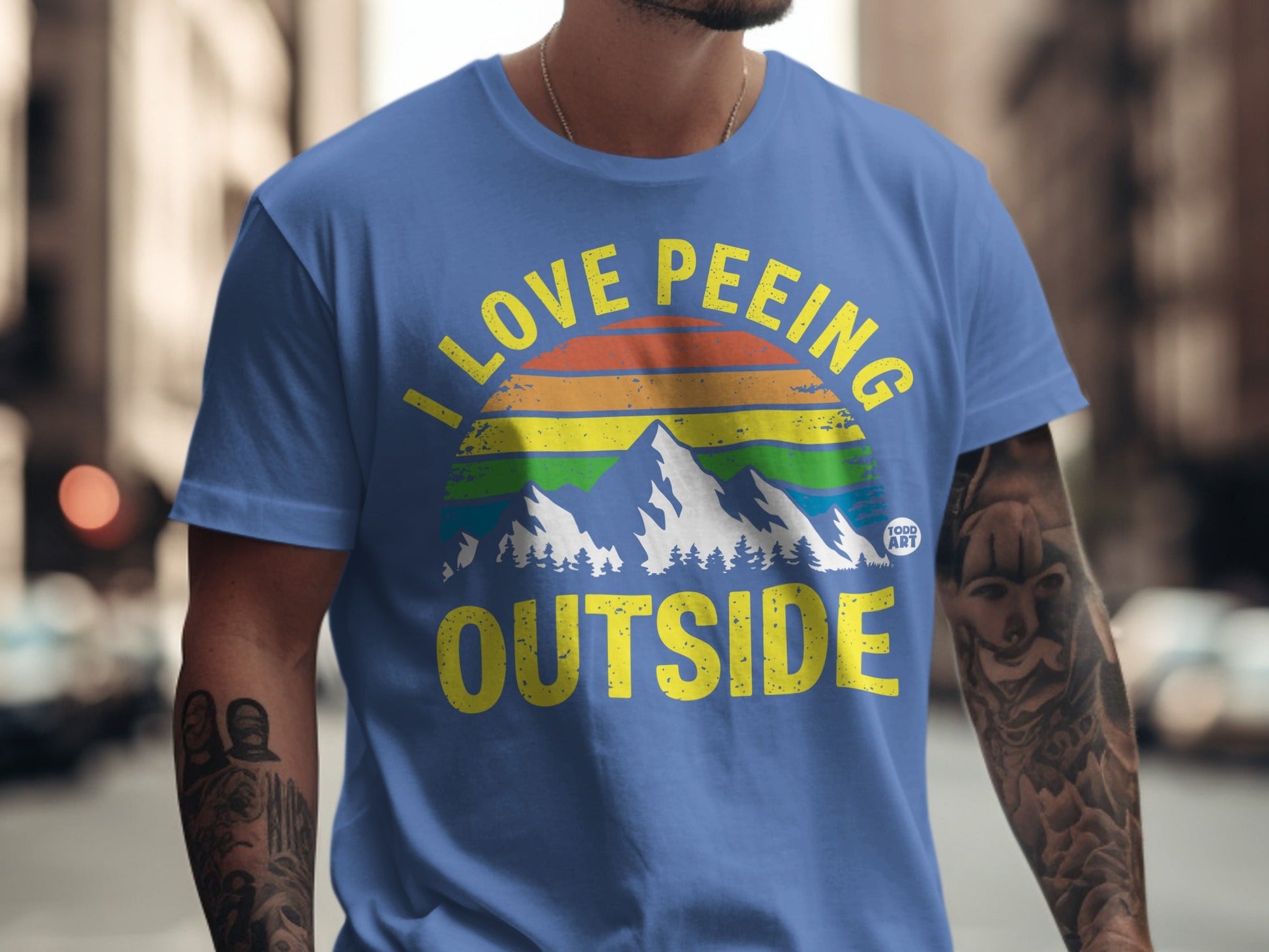 Blue t-shirt with "I love peeing outside" and rainbow mountain graphic.