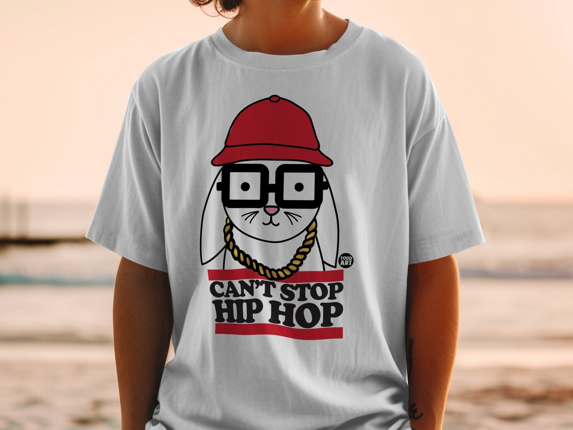 White t-shirt with "Can't Stop Hip Hop" text and cartoon rabbit wearing glasses and hat.